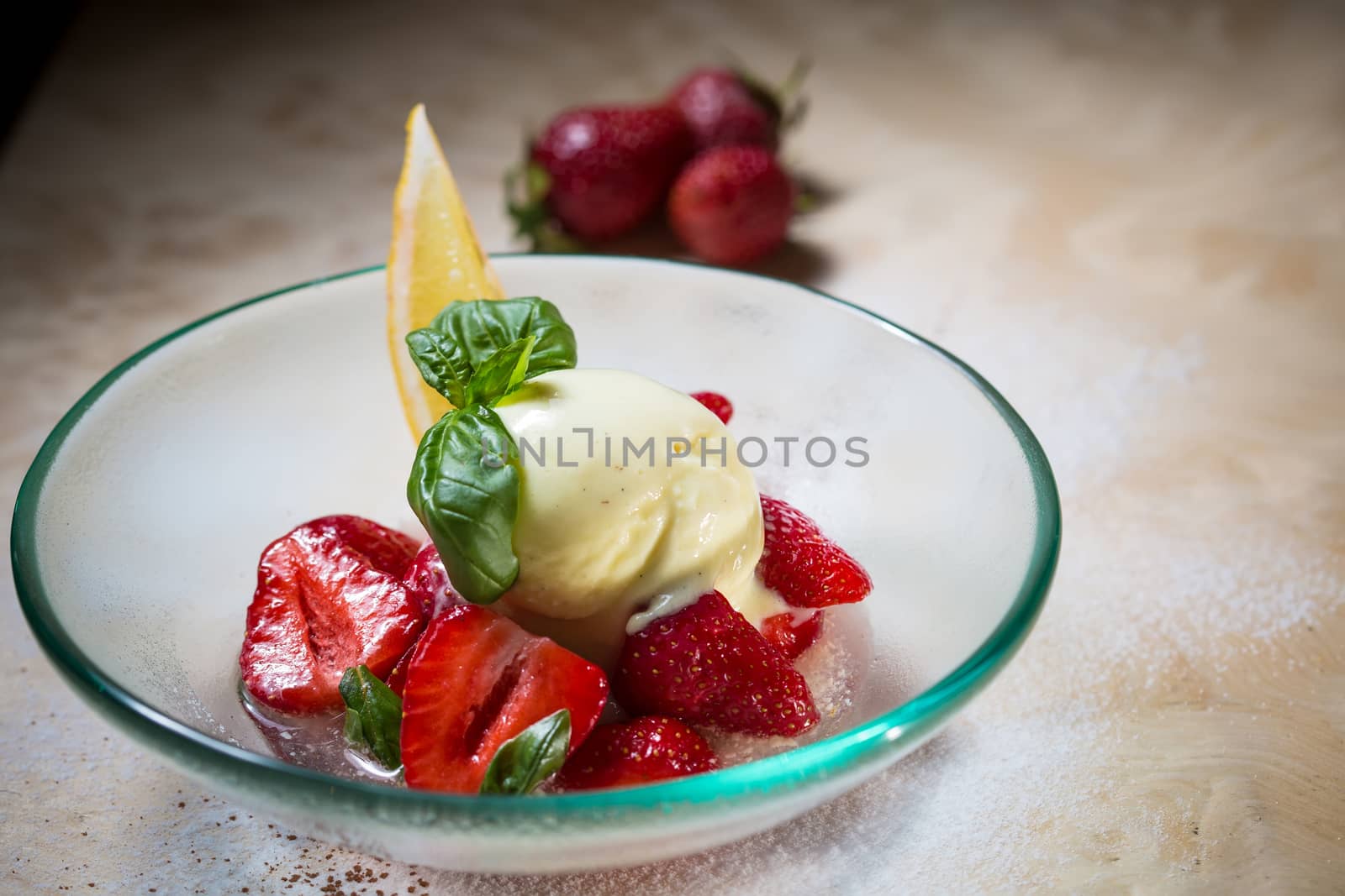 Ice cream with fresh strawberries in glass bowl