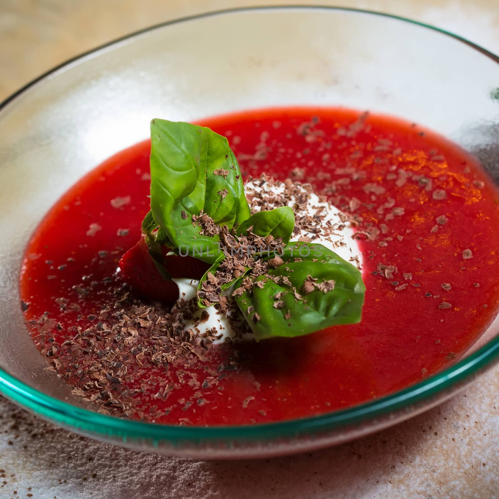 strawberry soup with ice cream and mint on a plate decorated fresh strawberries and chocolate