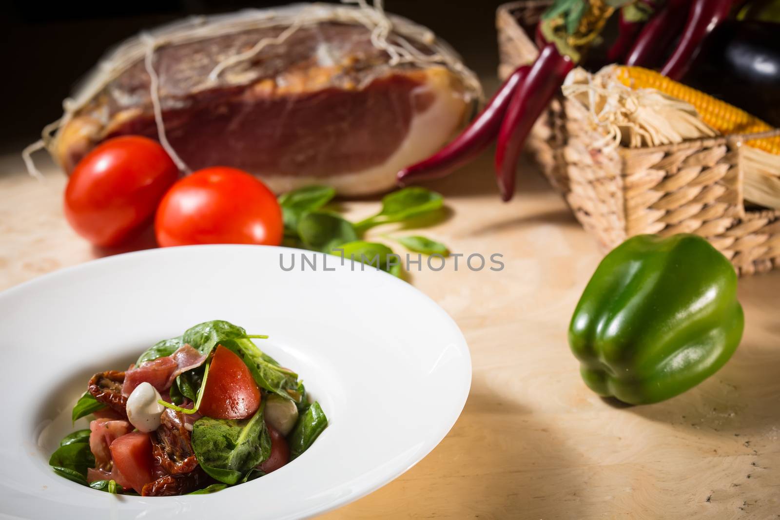 Salad with strawberry, prosciutto, herbs, cottage cheese and blackberry balsamic vinegar. Shallow dof.