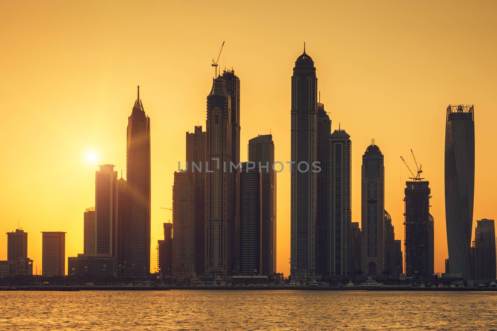 View of Dubai with sun at sunrise, UAE.