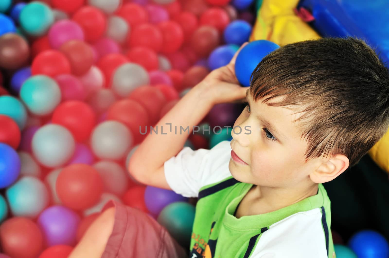 boy in the theme-park having fun in ball pool 