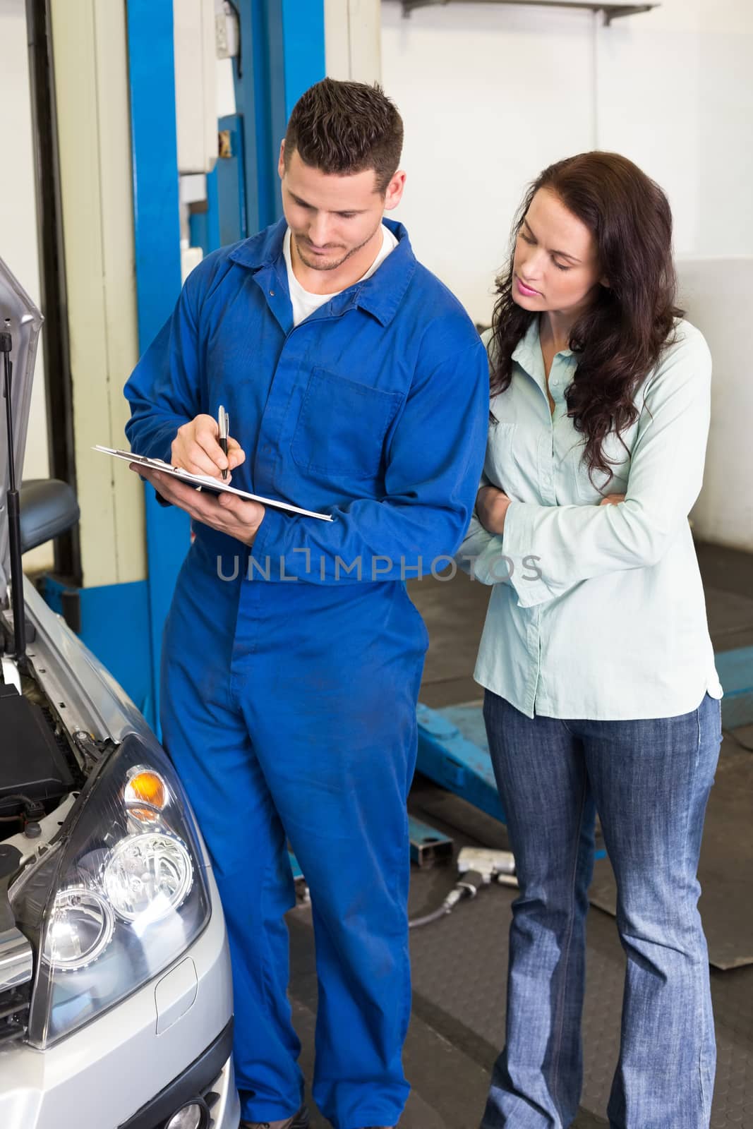 Mechanic and customer standing together at the repair garage