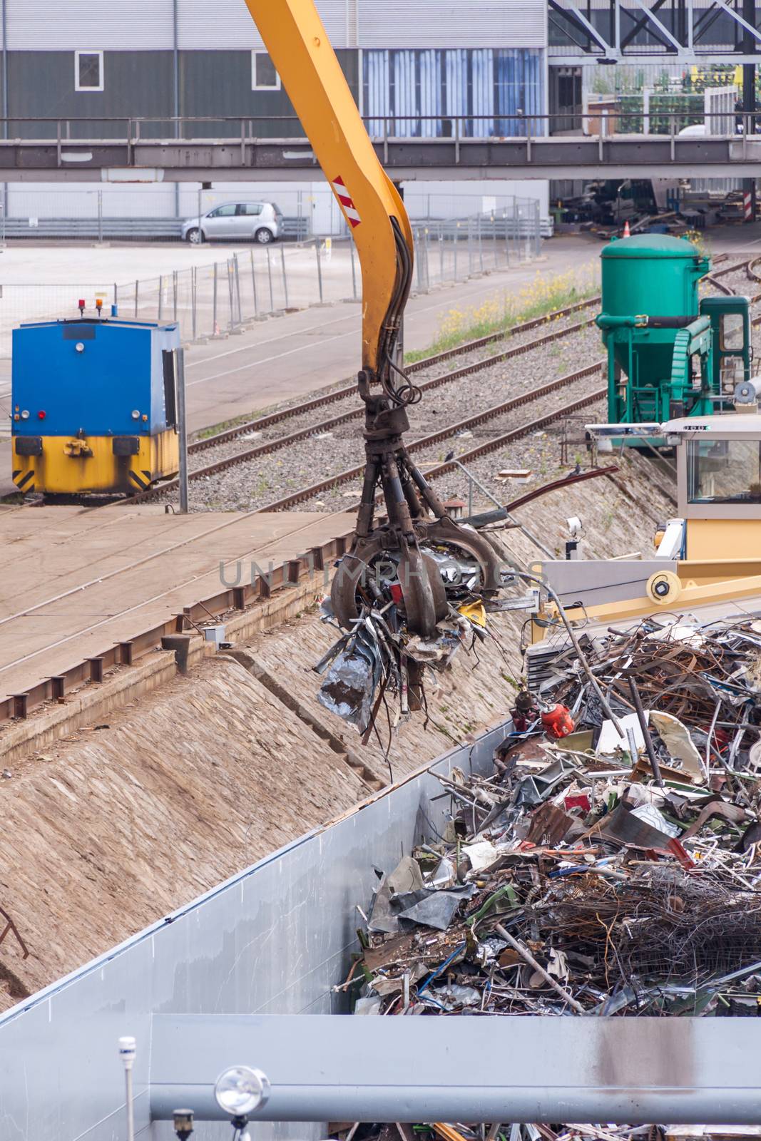 Open barge being loaded or offloaded at a wharf on an urban waterway or river by a heavy duty industrial crane