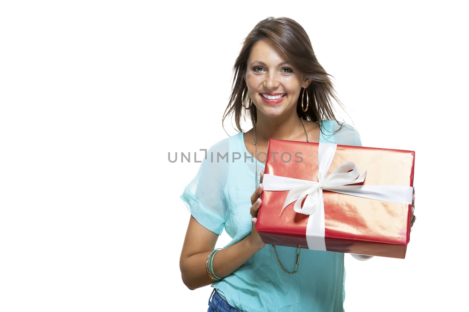 Close up Portrait of Happy Young Woman in Casual Clothing Holding a Red Big Gift Box with White Ribbon While Looking at the Camera. Isolated on White Background.