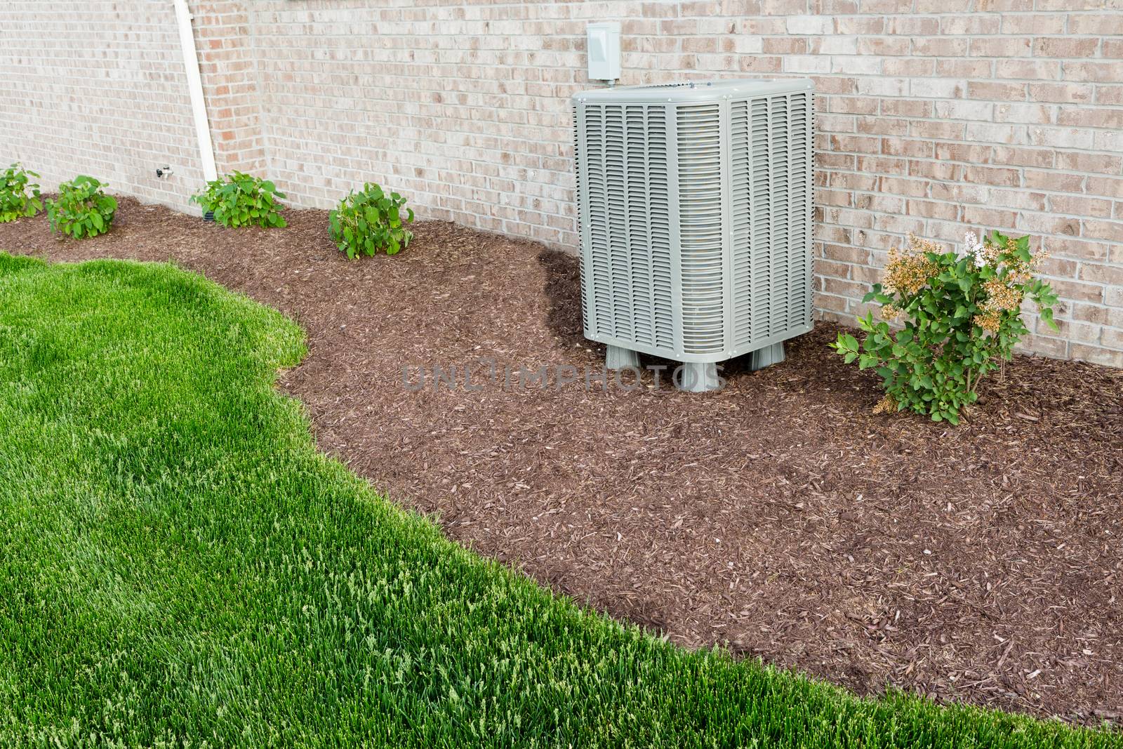 Air conditioner condenser unit standing outdoors by coskun