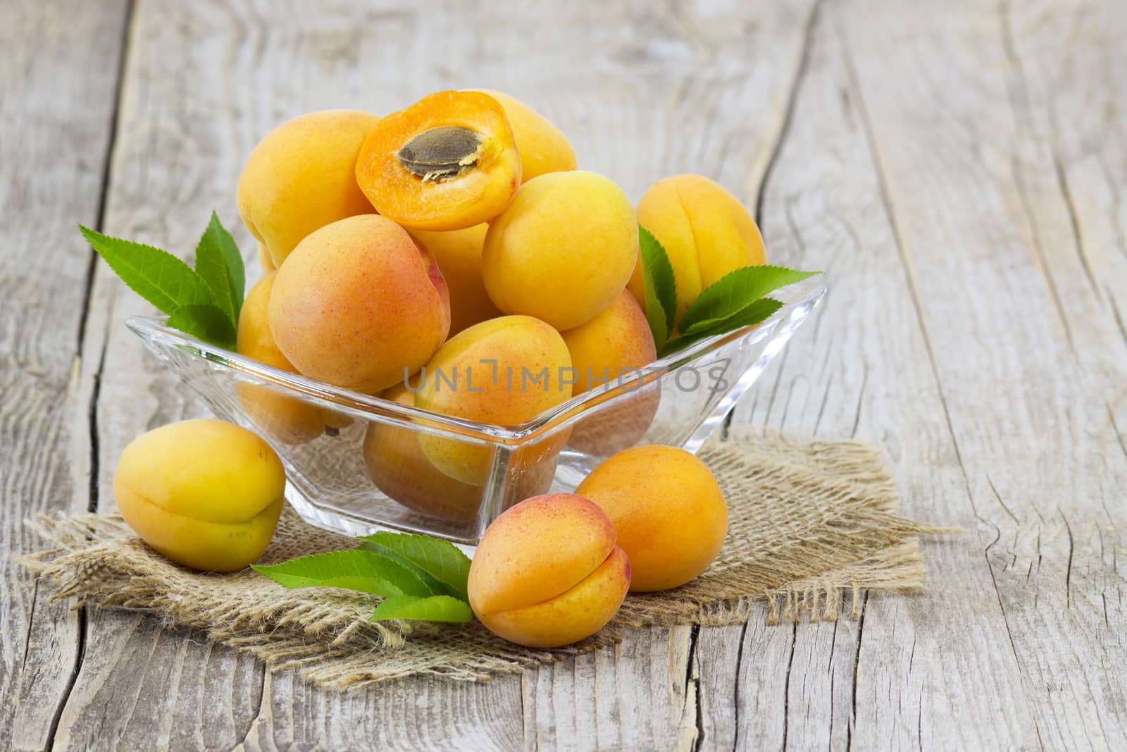 fresh apricots in a bowl on wooden background