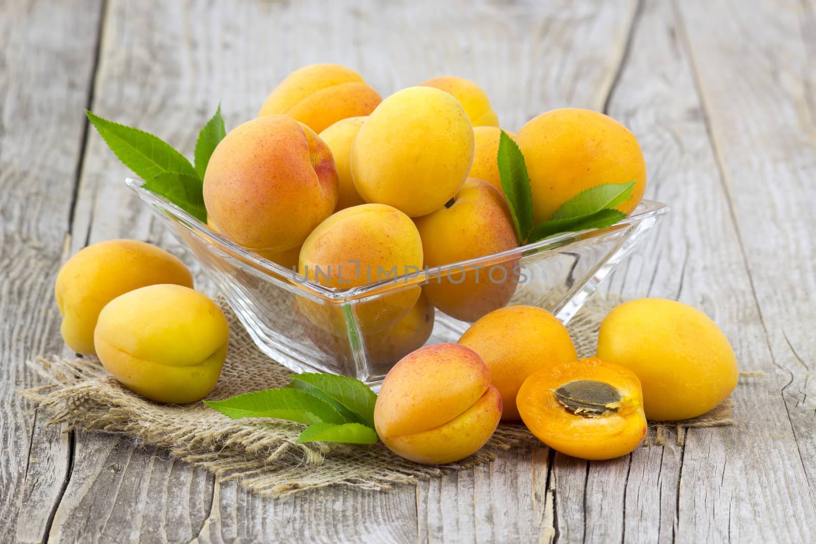 fresh apricots in a bowl on wooden background