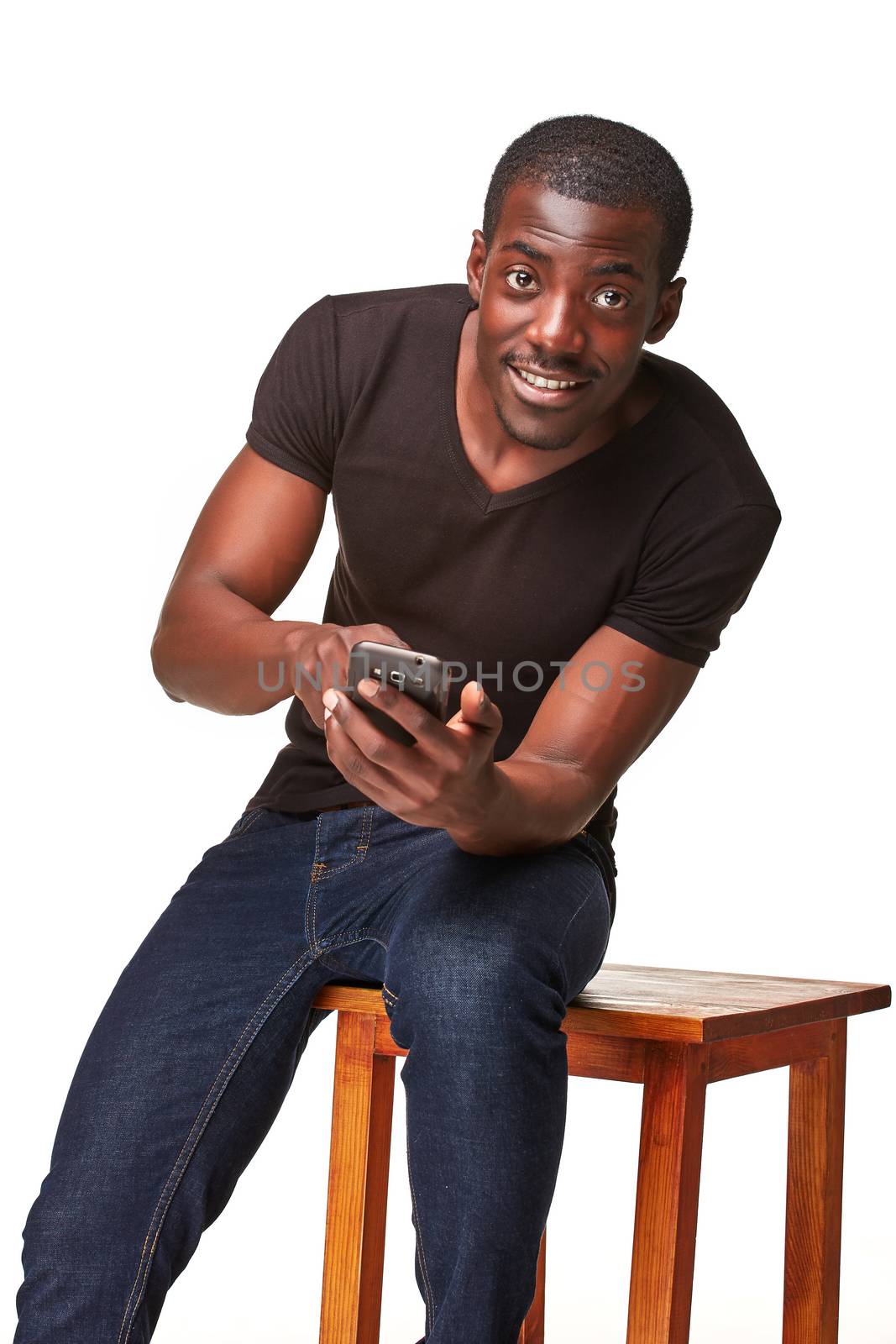 Portrait of smiling african man sitting on the chair and  talking on the phone, isolated on a white background