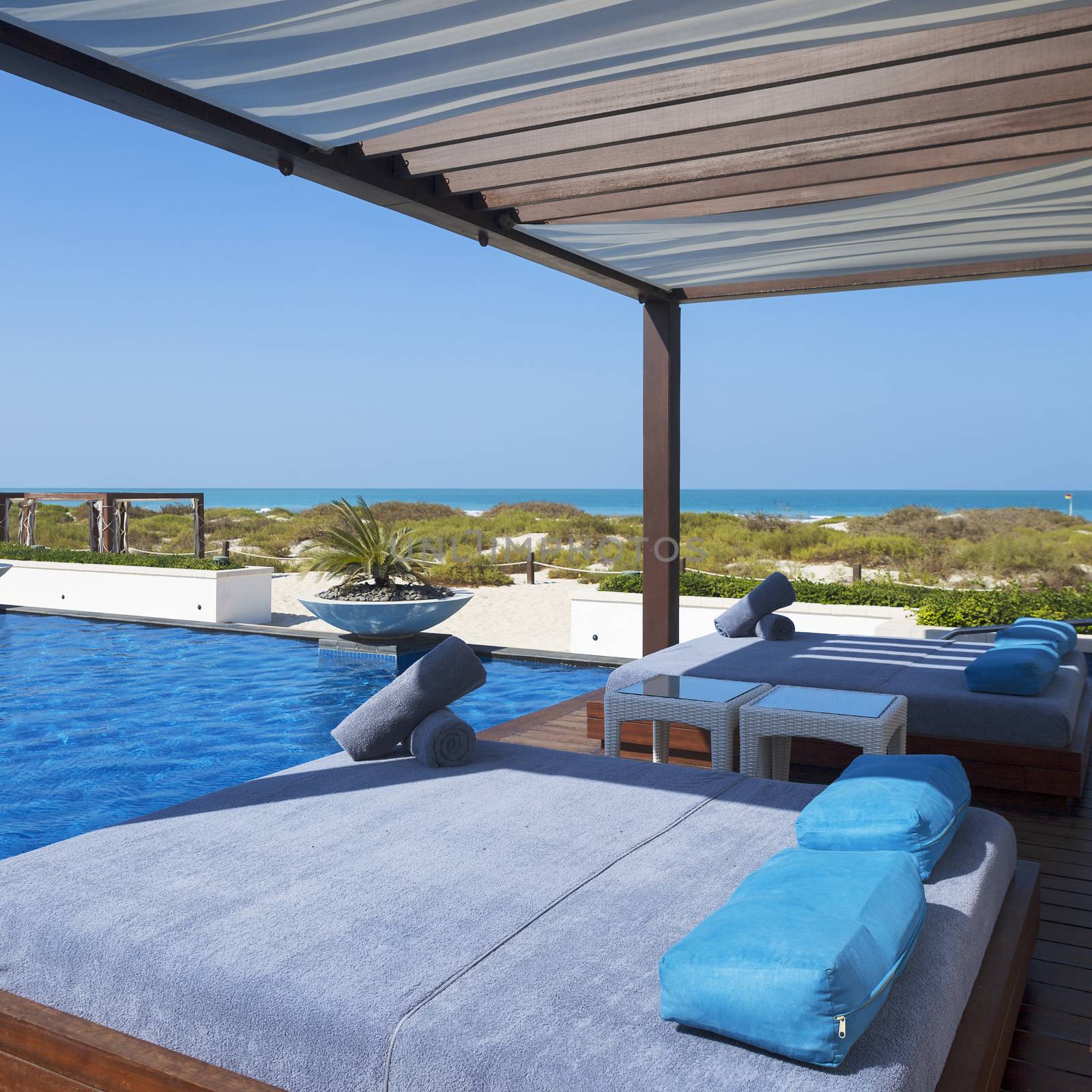 Bed near swimming pool and beach.