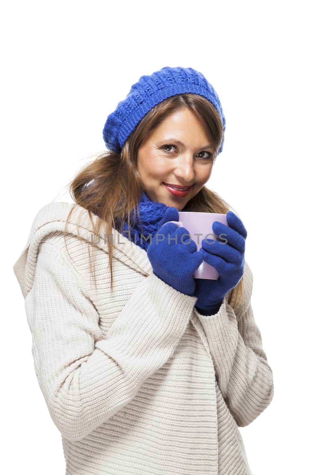 Close up Pretty Smiling Young Woman Wearing Winter Knit Outfit with Blue Bonnet, Scarf and Gloves. Captured in Studio with White Background While Looking at the Camera.