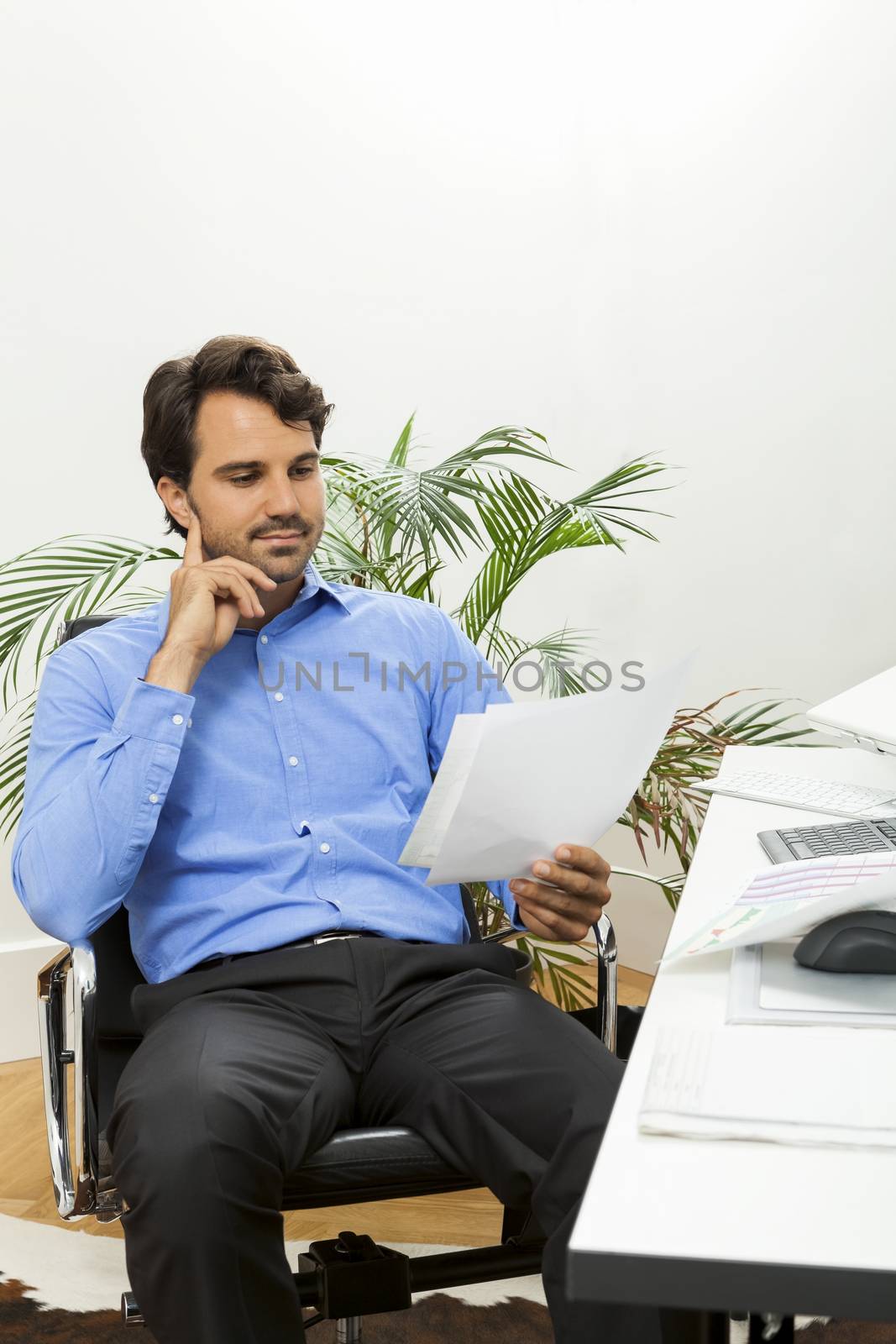 Young man reading written agreements for work by juniart