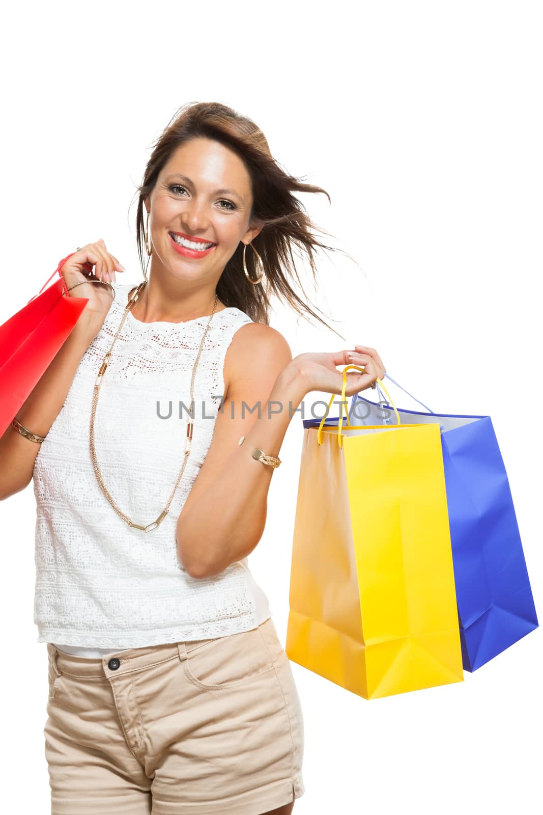 Very Happy Stylish Woman Raising Three Colored Shopping Paper Bag with Mouth Open and Looking at the Camera. Isolated on White Background.