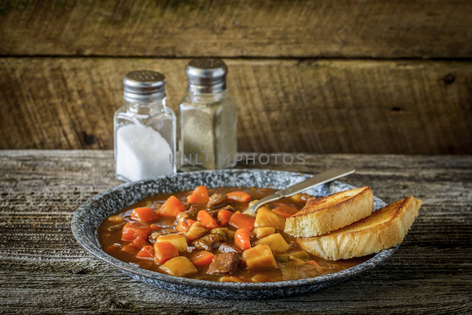 Plate of hearty beef stew on a rustic background.