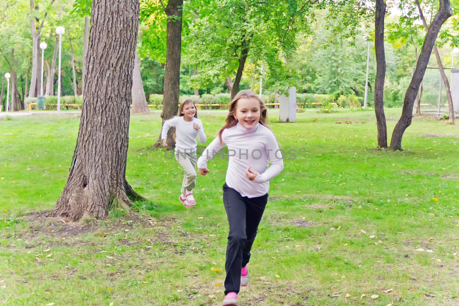 Photo of two running girls in summer