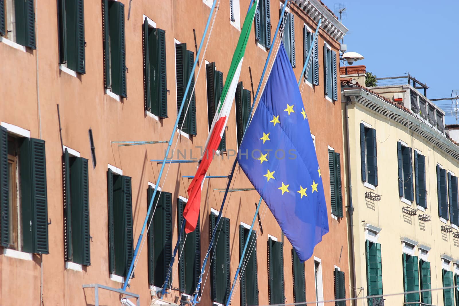 Italian and European flag on the wall of a building in Venice, Italy