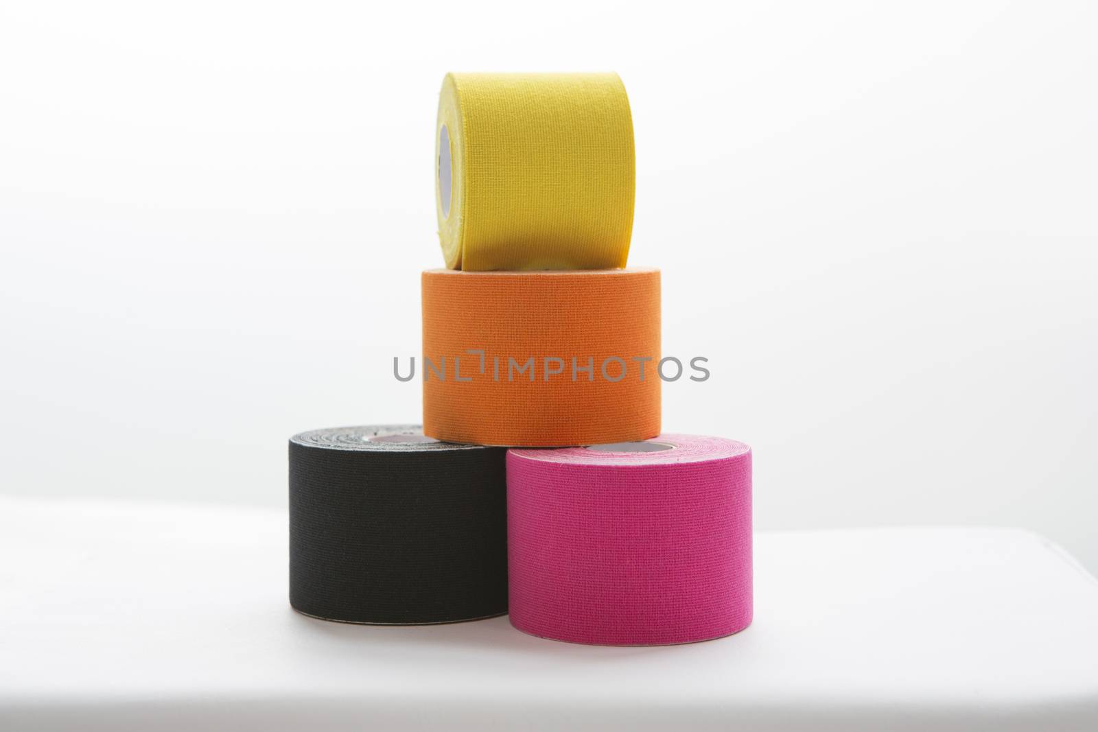 four physiotheraphy belts, black, pink, orange and yellow