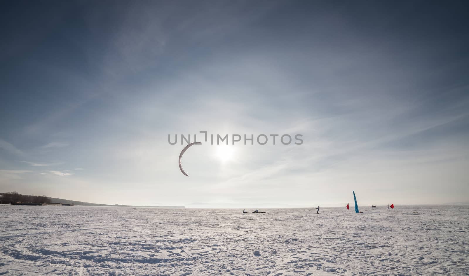 Kite surfer being pulled by his kite across the snow