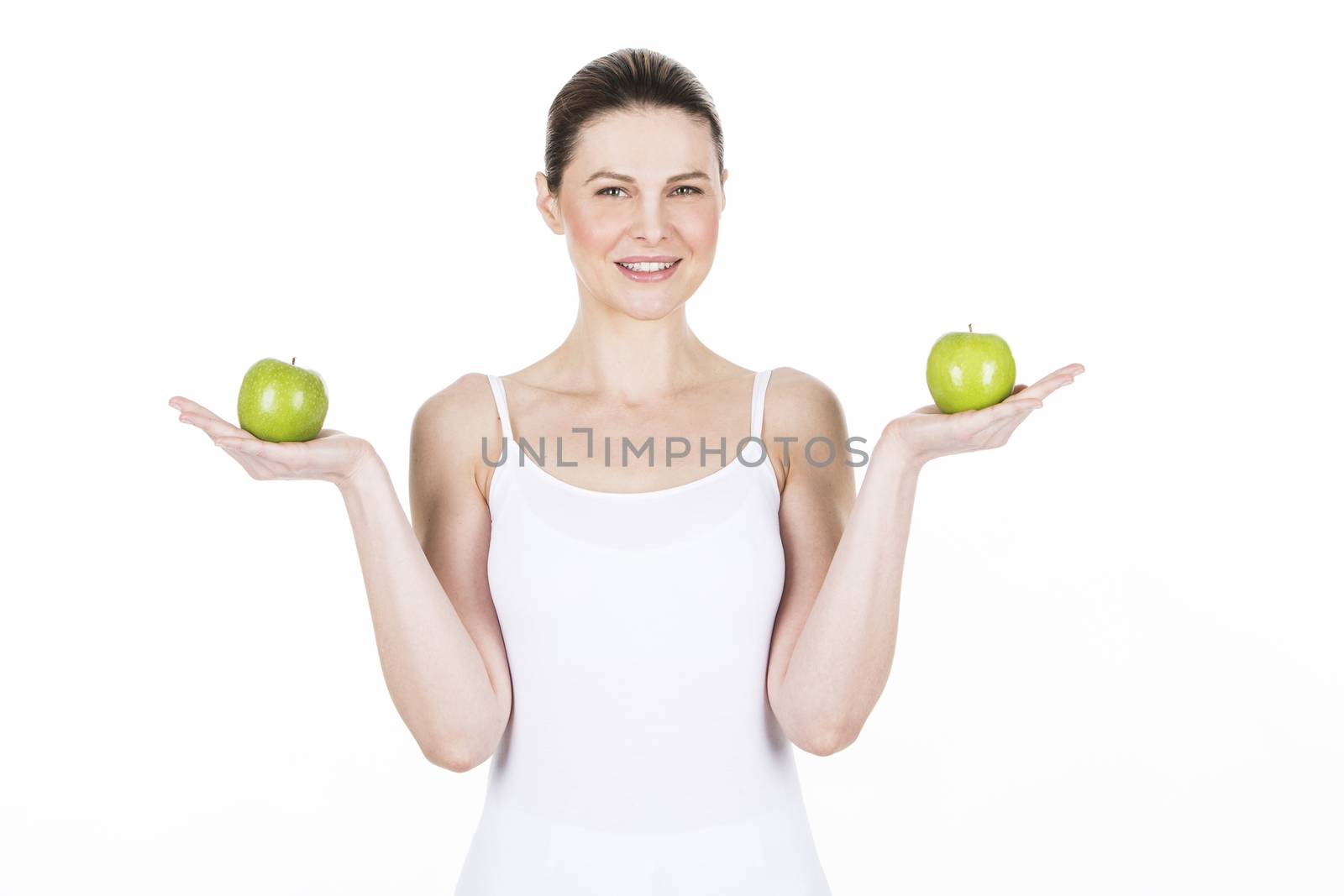 young woman holding two 
apples and looking at camera
