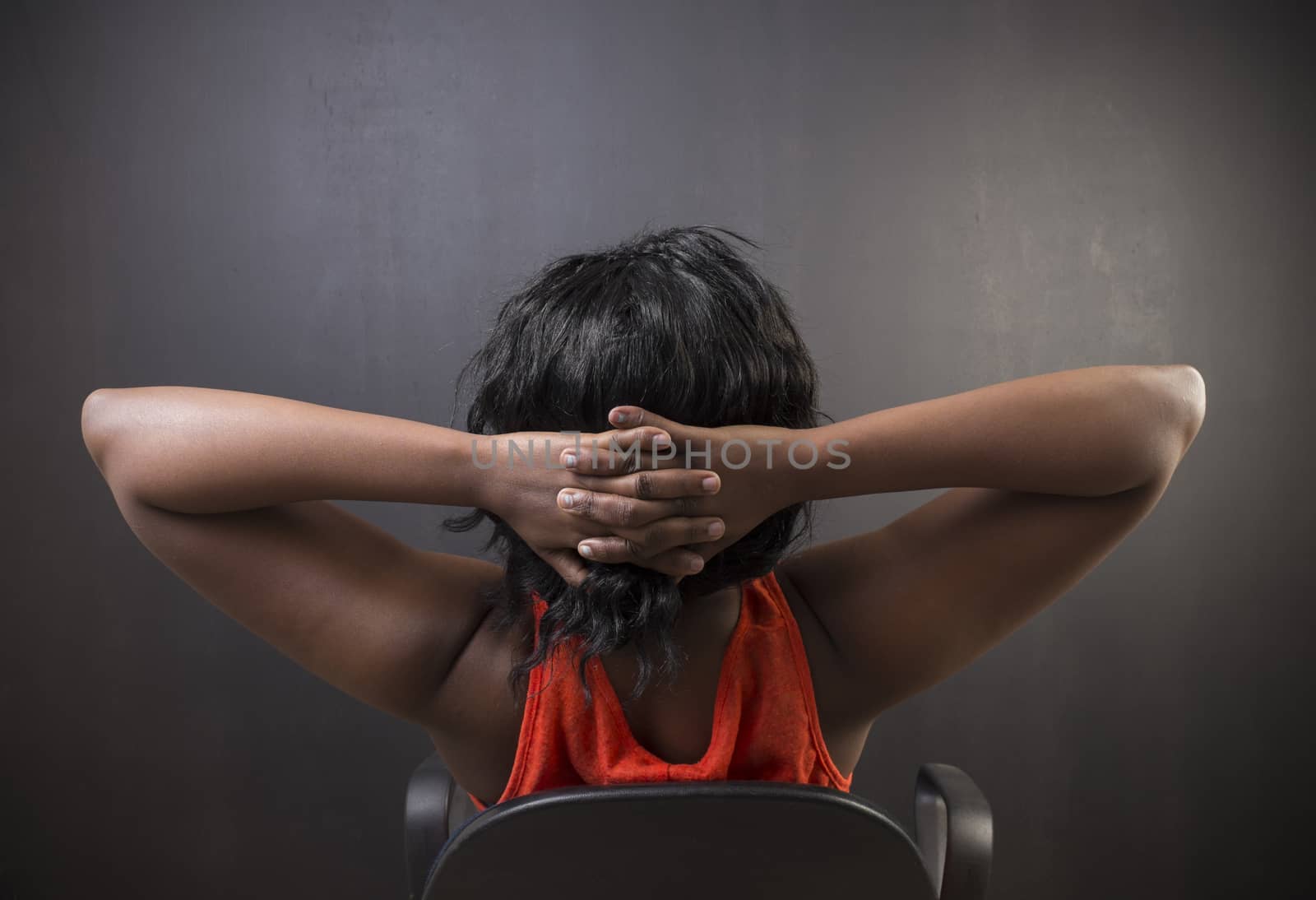 South African or African American woman teacher or student relaxing on chair by alistaircotton