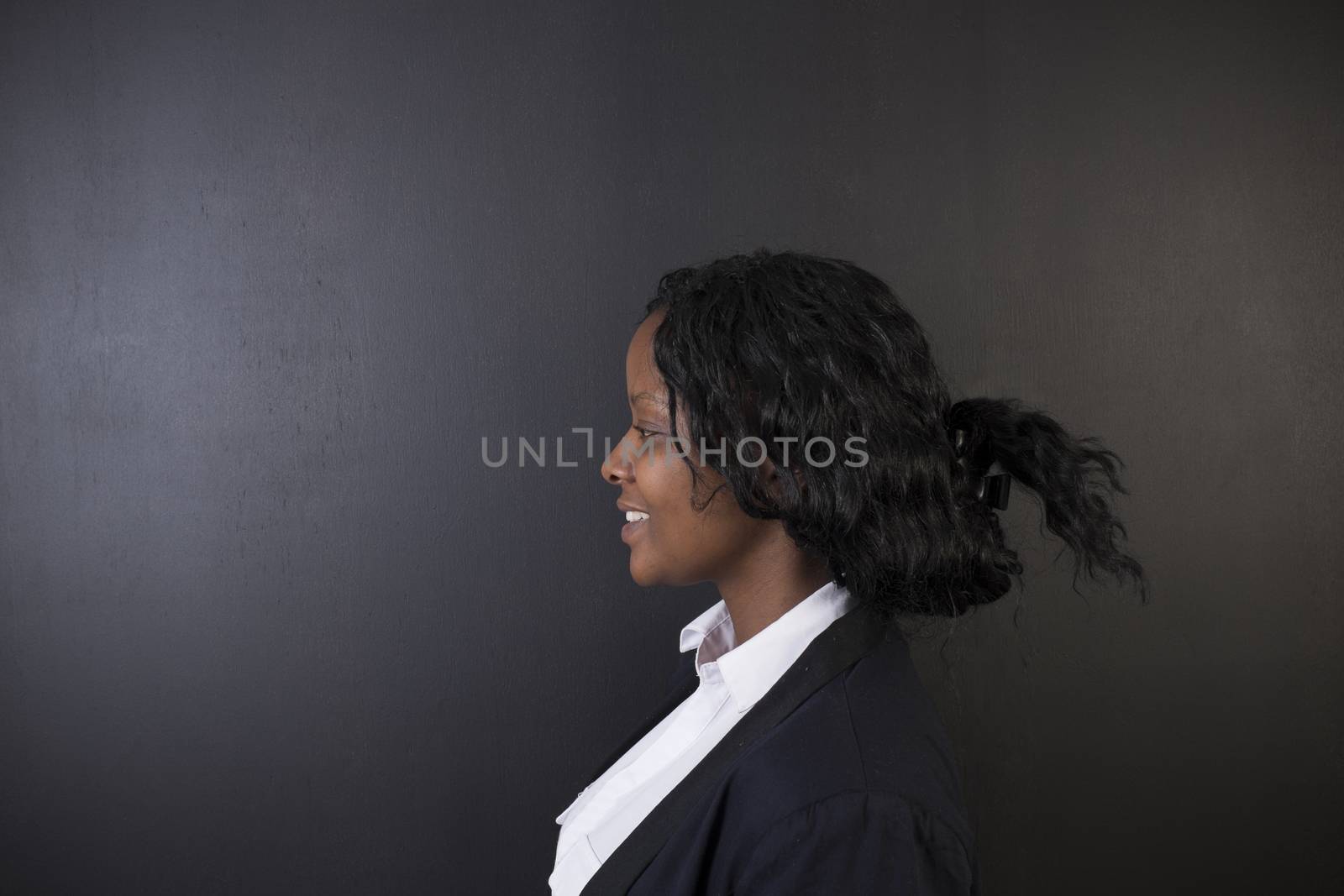 South African or African American woman teacher on chalk black board background