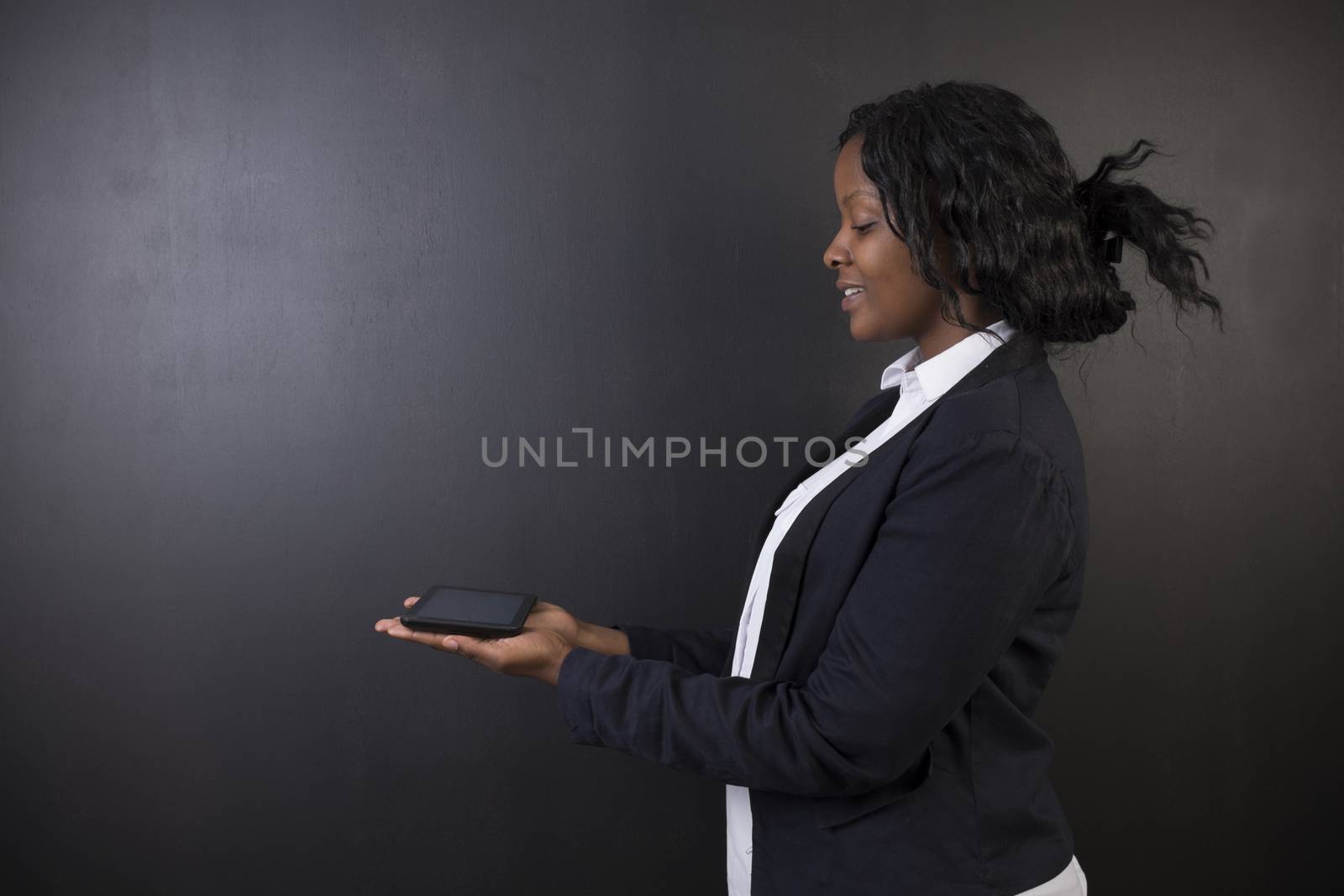 South African or African American woman teacher or student holding tablet by alistaircotton