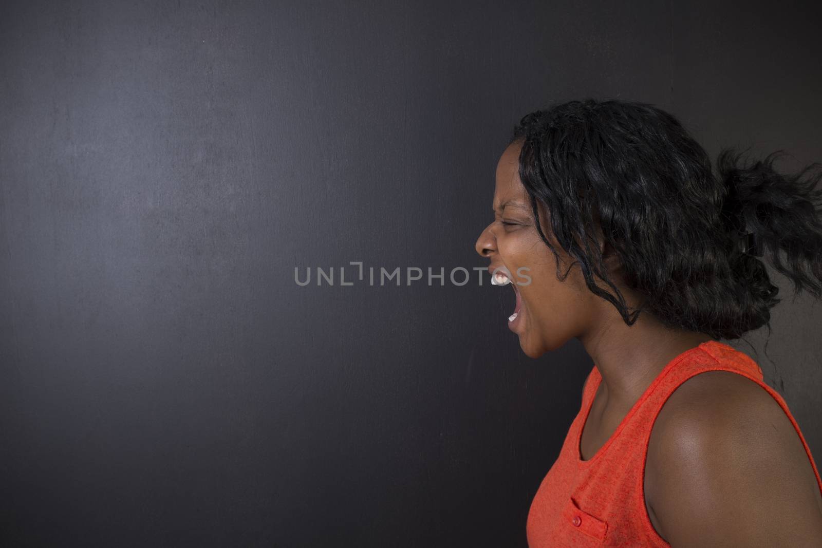 Angry South African or African American woman teacher shouting on blackboard background