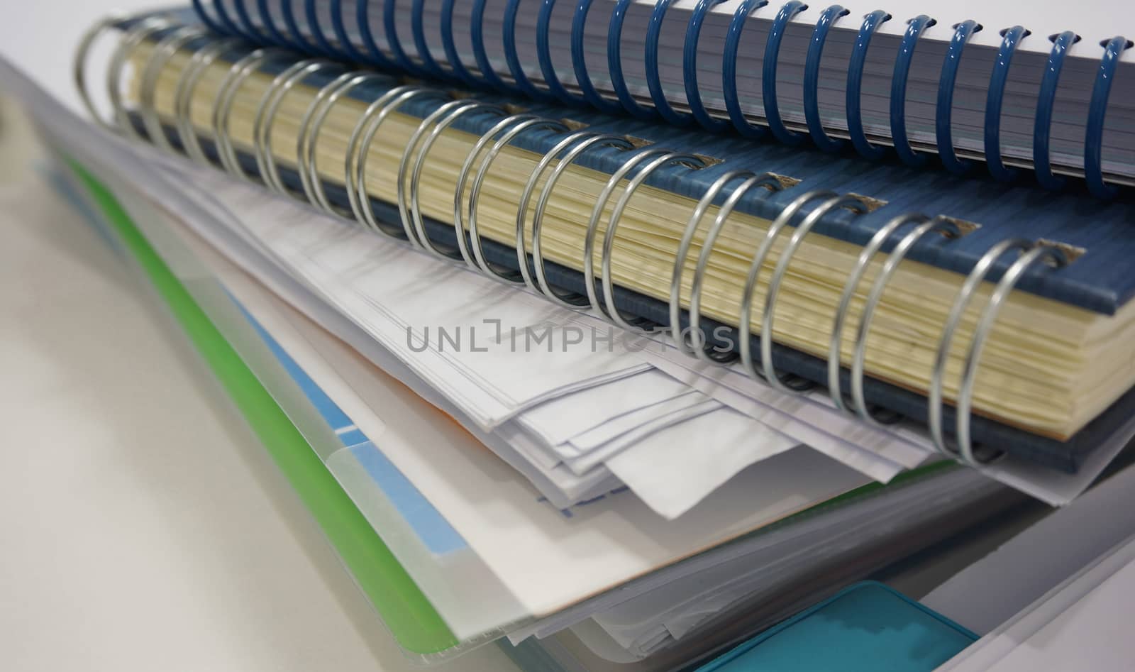 Stack of office document and ring binder book on desk by ninun