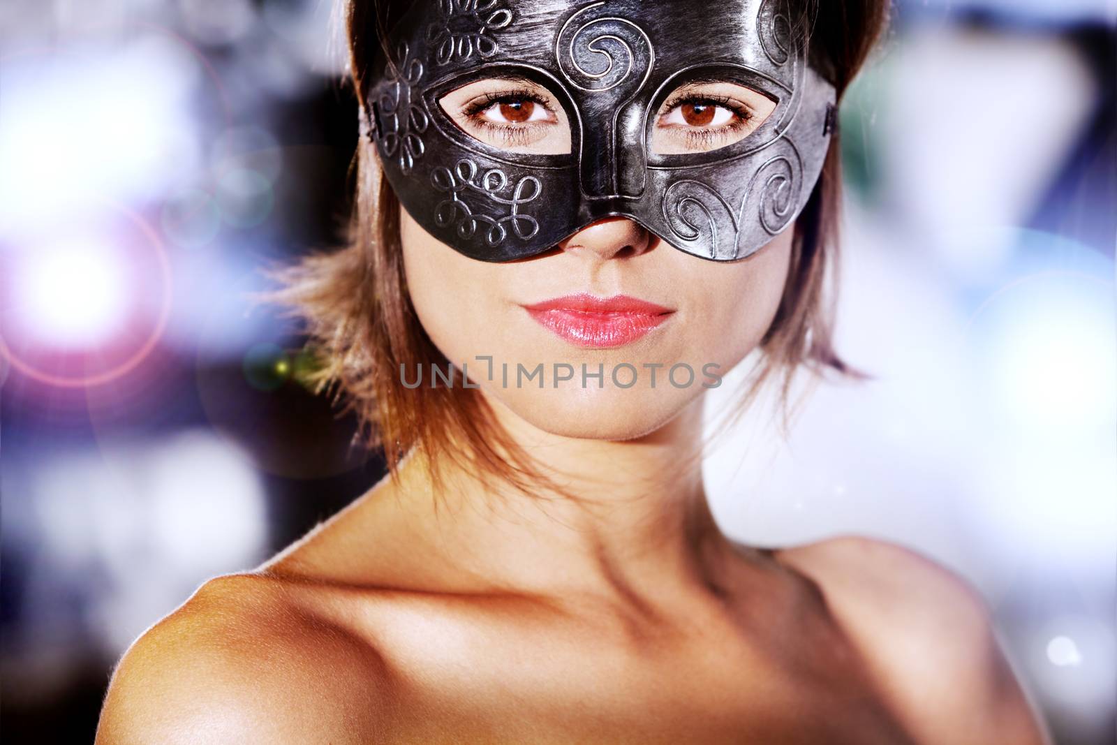 Portrait of beautiful and mysterious woman with carnival mask with city lights background.Fashion