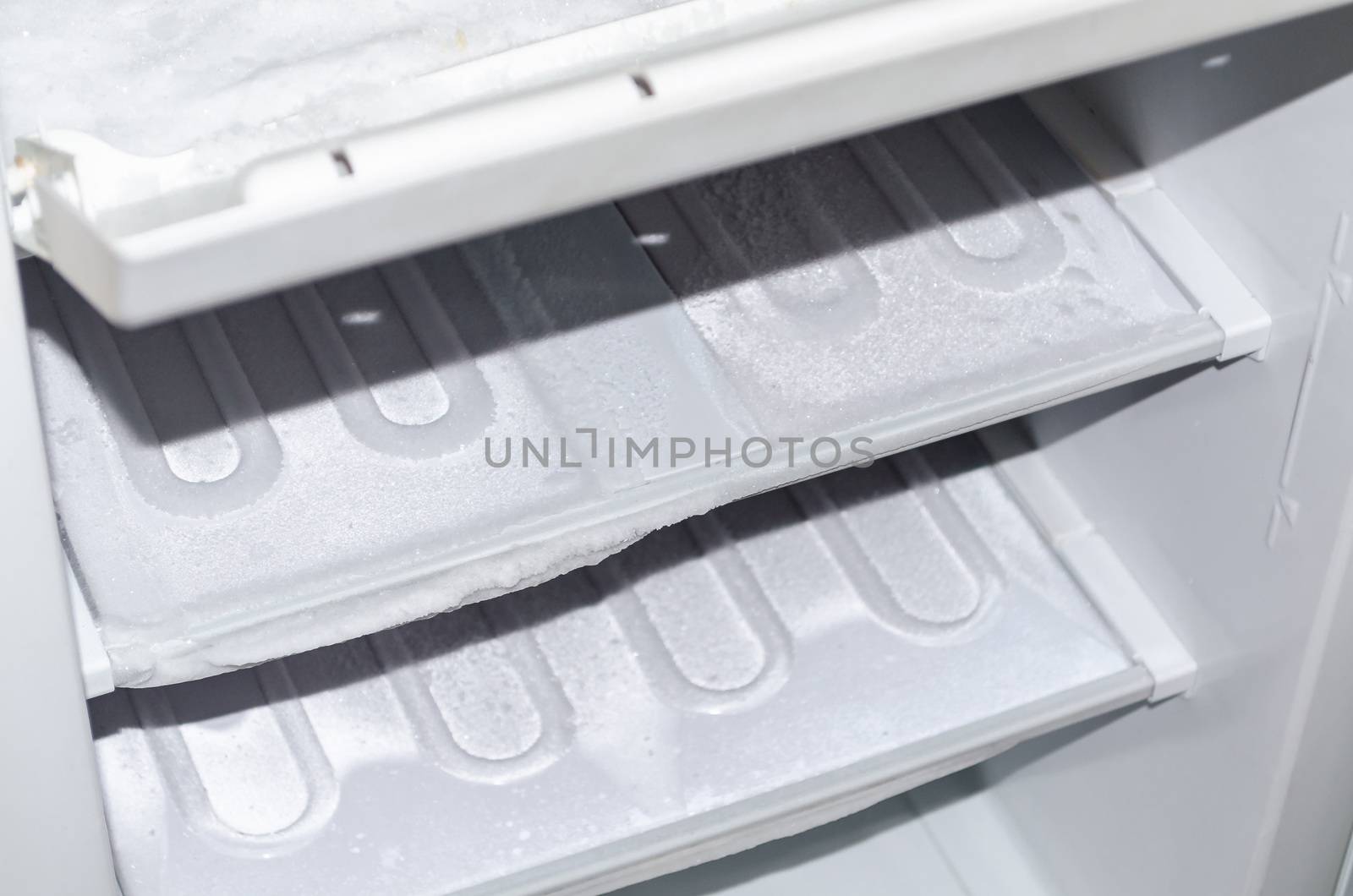 View of an empty freezer that will defrost.