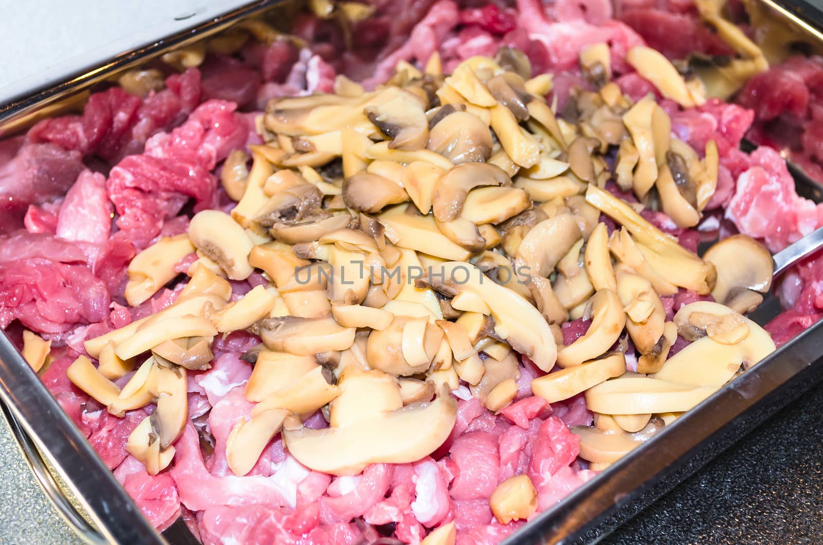 Stroganoff with mushrooms raw, hand-cut in front of white background.