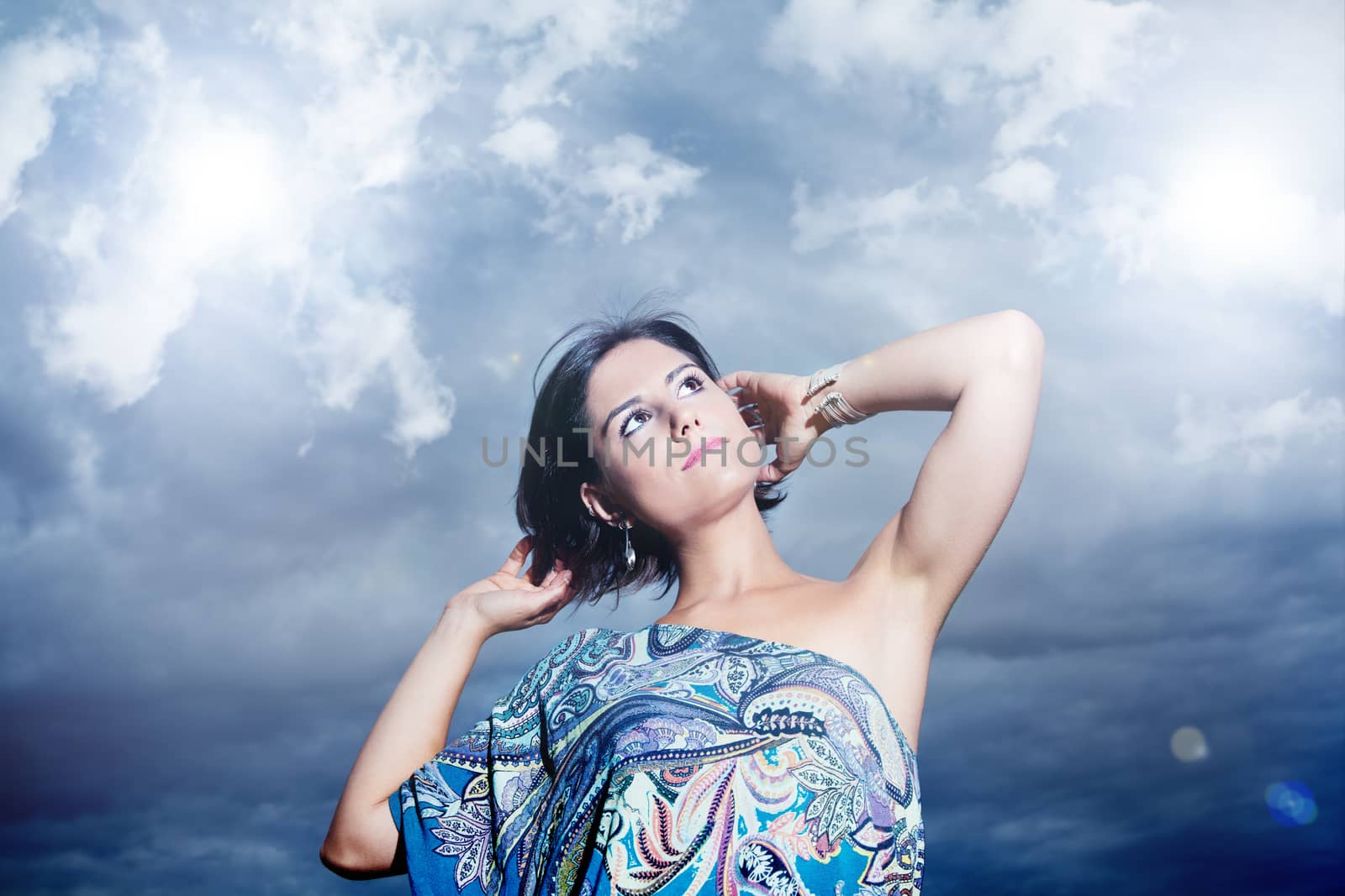 beautiful young woman on a background of sky and clouds expressing purity and freedom. Fashion