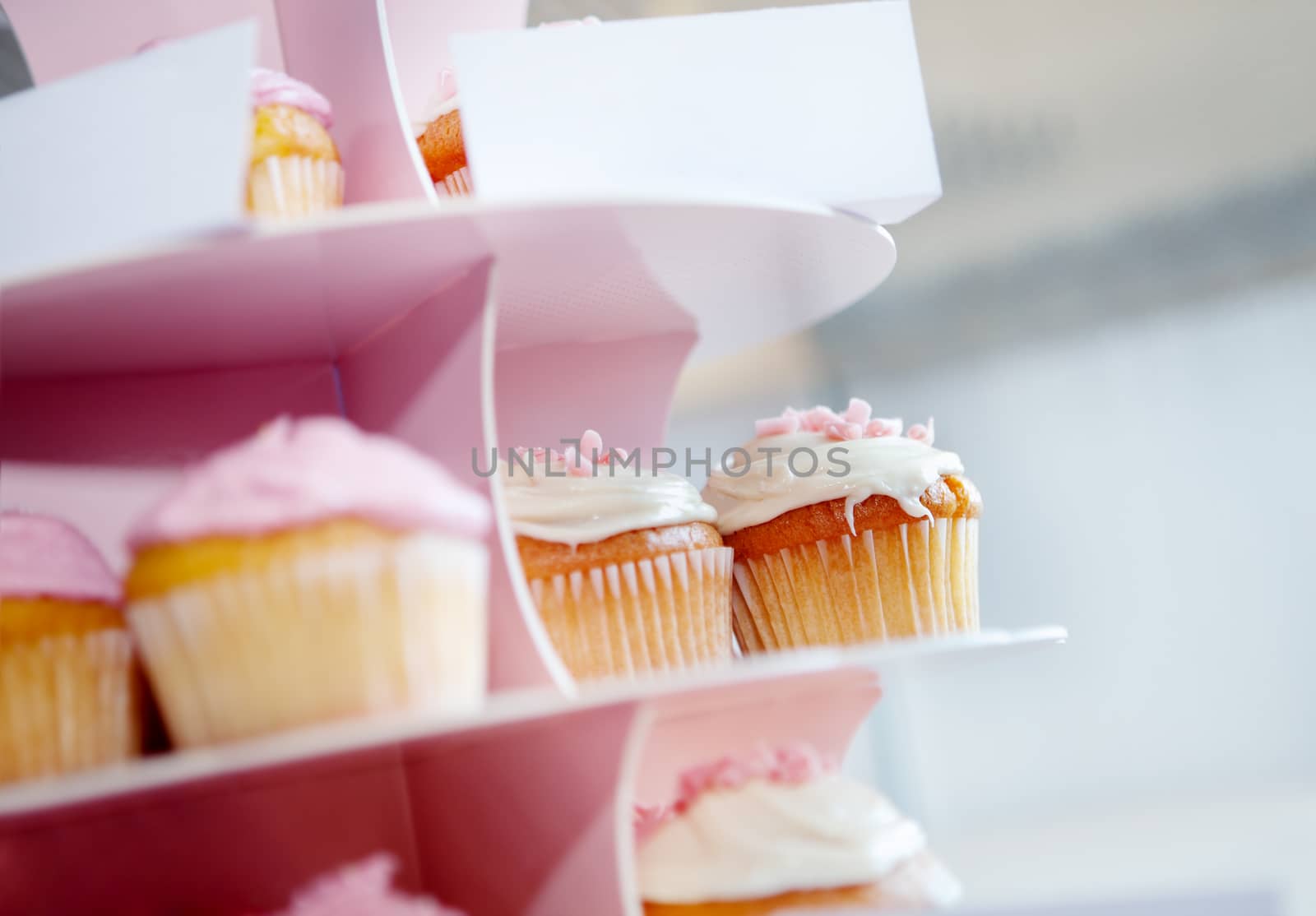 Desserts and sweets for parties. sweets for celebrations. Pink cupcakes and chocolate with whipped cream in cupcake stand.