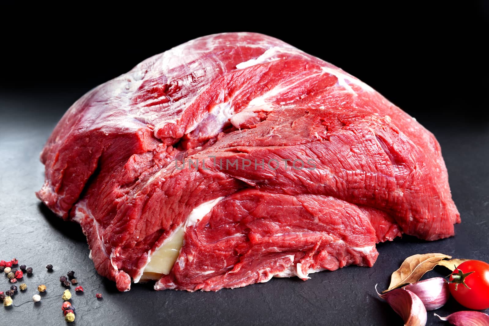 Fresh and raw meat. Whole piece of red meat ready to cook on the grill or BBQ .Background black blackboard. Food