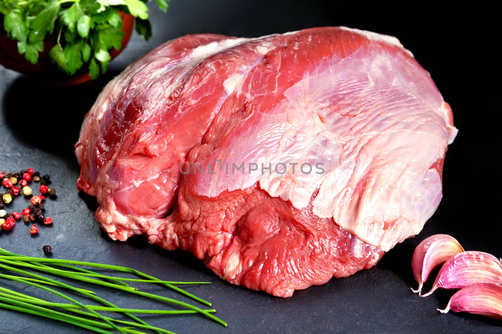 Fresh and raw meat. Whole piece of red meat ready to cook on the grill or BBQ .Background black blackboard. Food