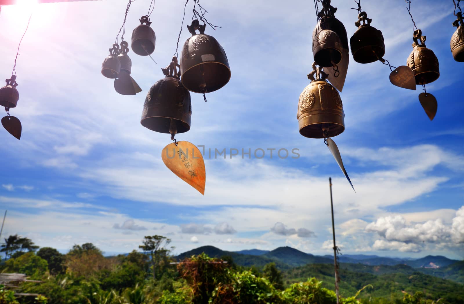 Row of golden bells in buddhist temple. Background of mountains in asia, tailandia.Buddha mountain