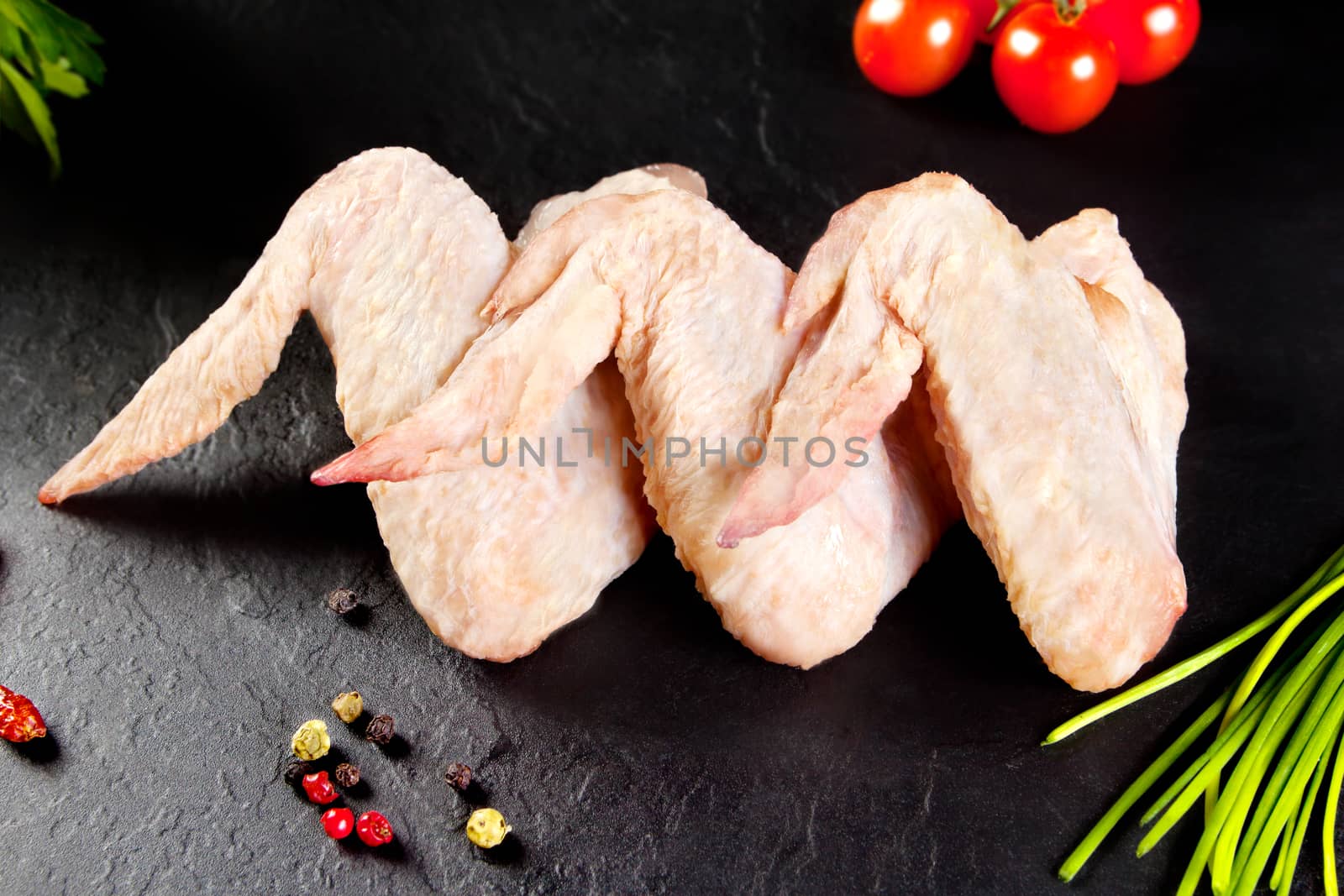 Fresh and raw meat. Chicken wings white  ready to cook. Background black blackboard. Food