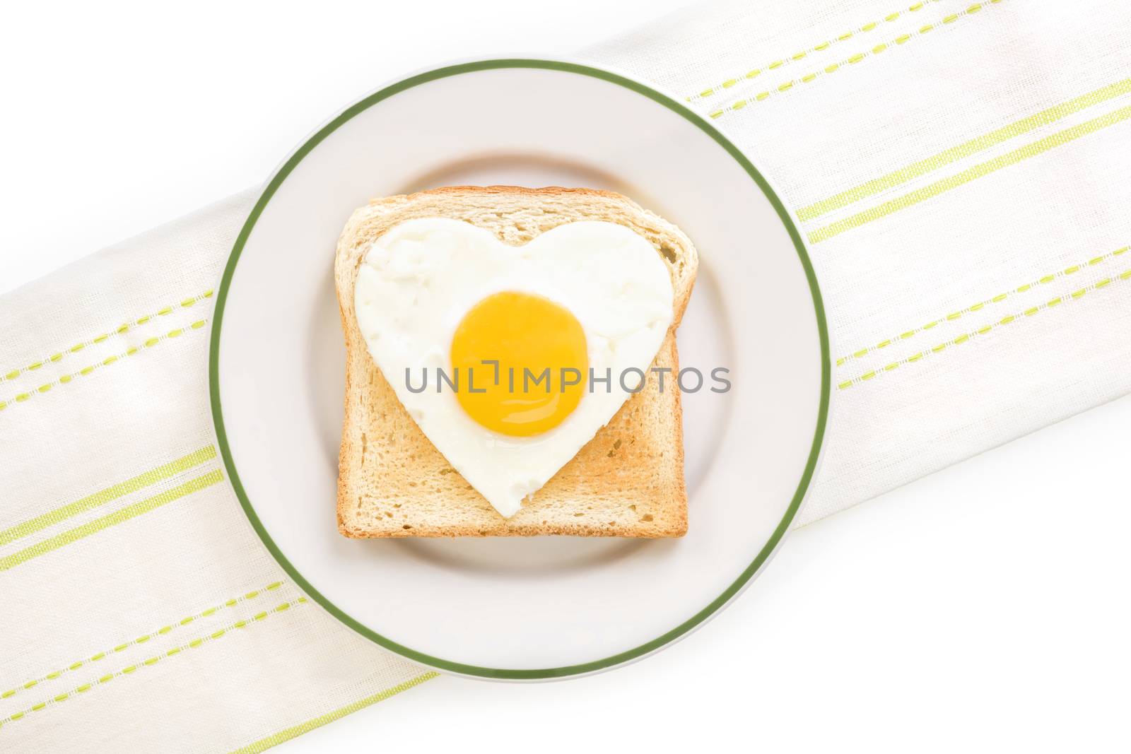 Fried egg sunnyside in heart shape on plate, top view. I love breakfast. Fresh modern image language. Culinary arts. 