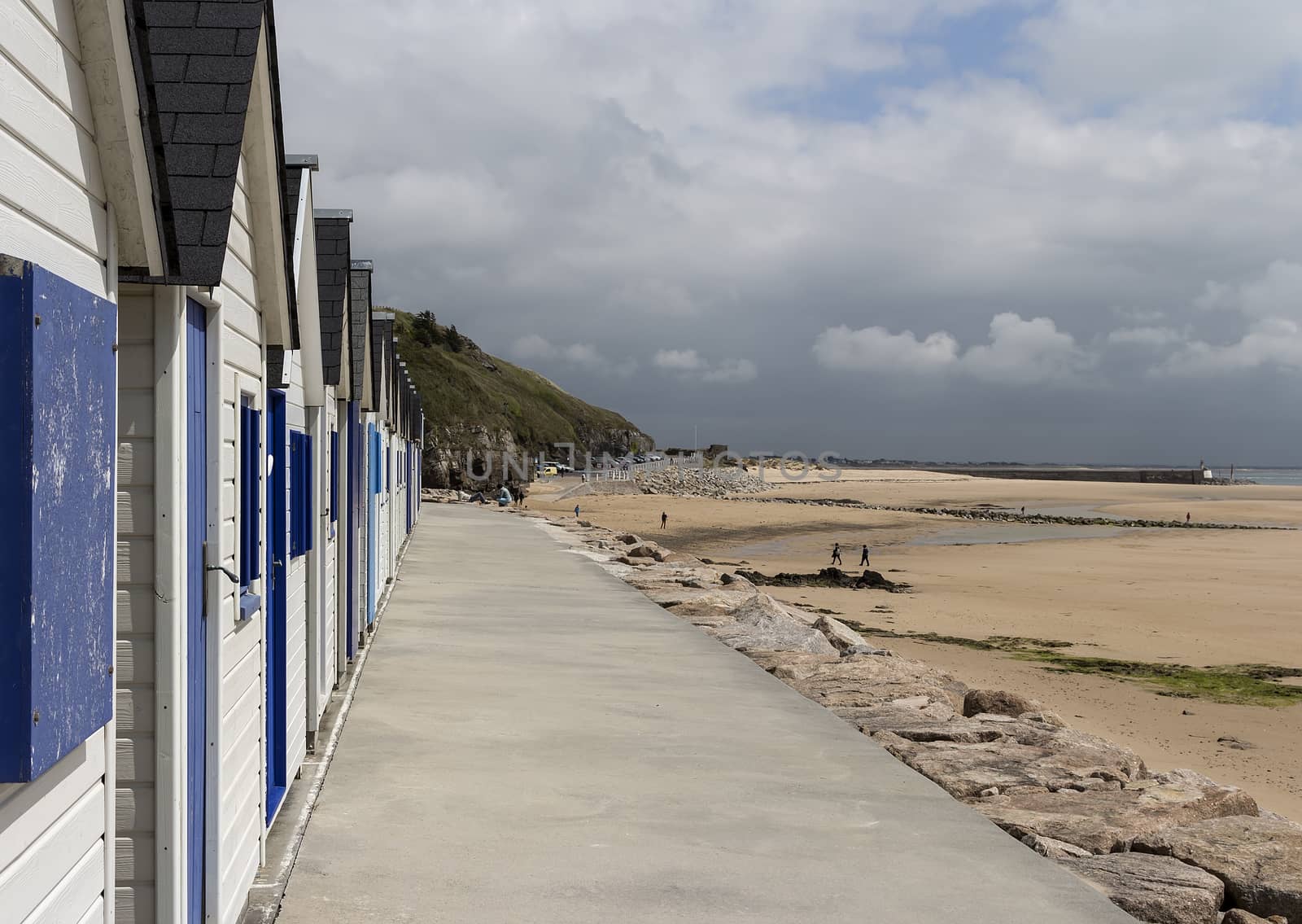 A set of cabins in a long row on a beach