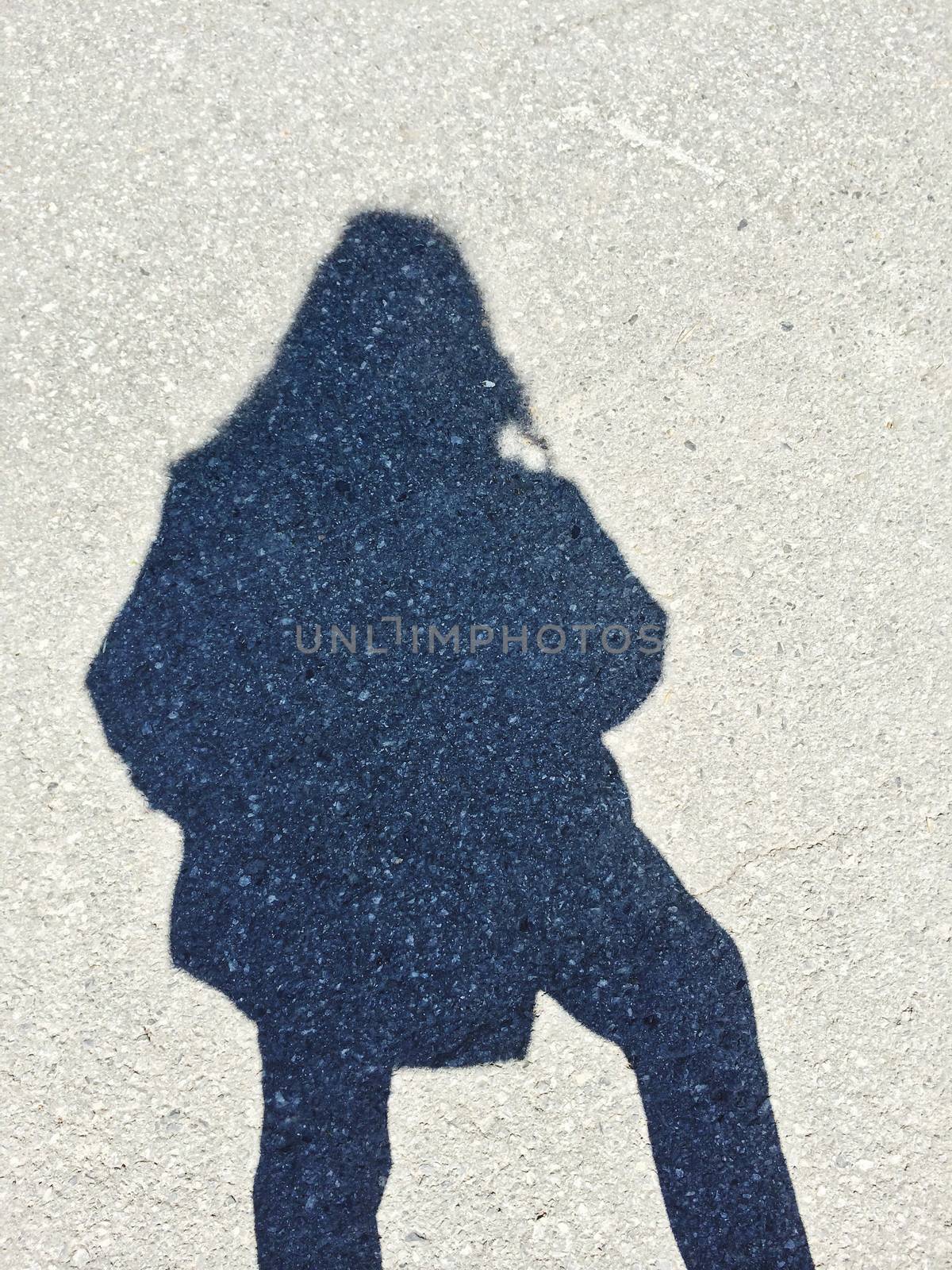 Shadow of a woman on gray concrete background.