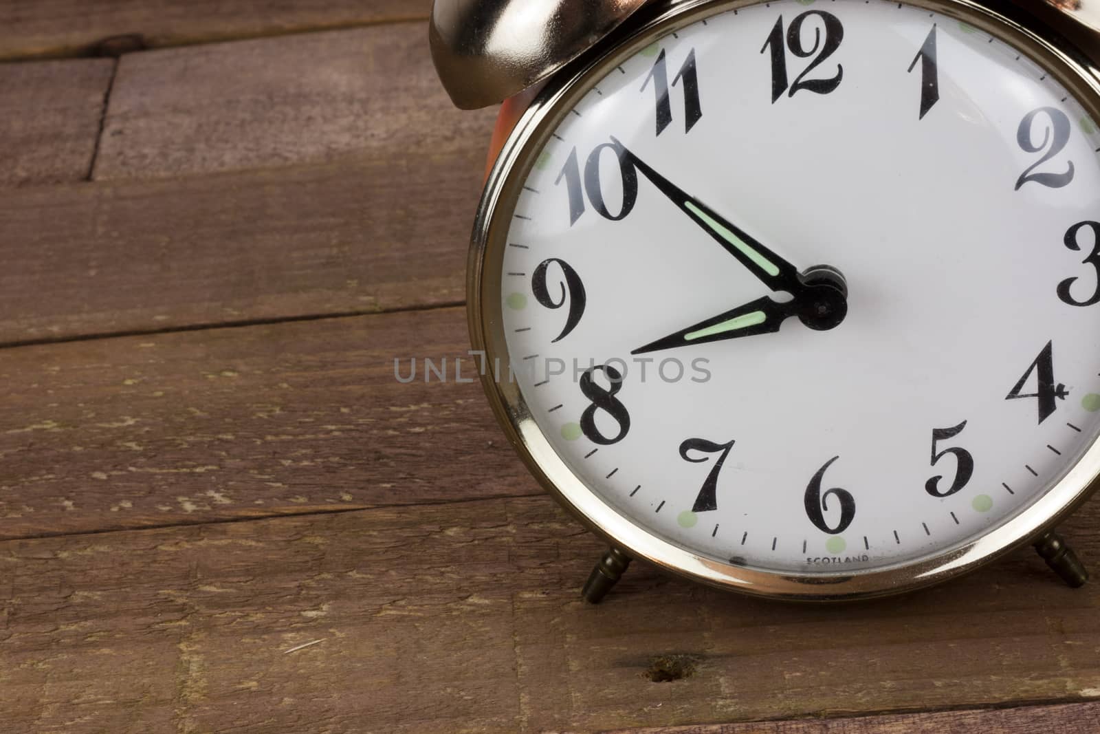Close up of a clock against a wooden background