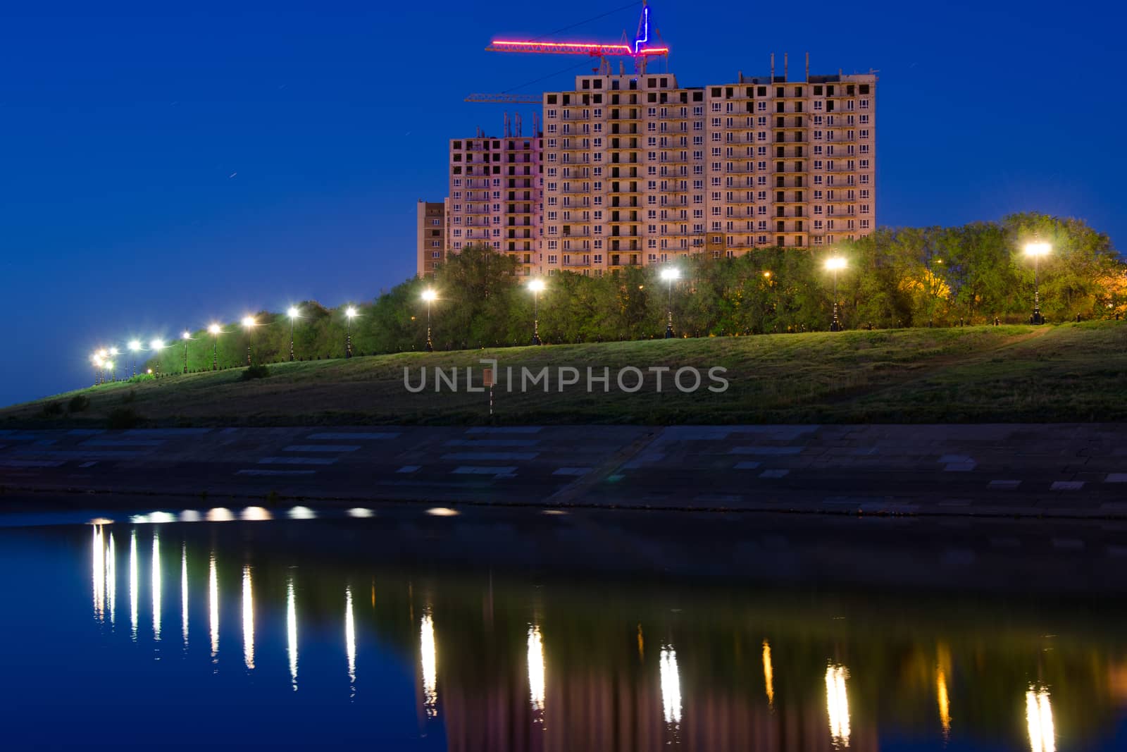 Evening view of the residential complex under construction high-rise buildings by the river
