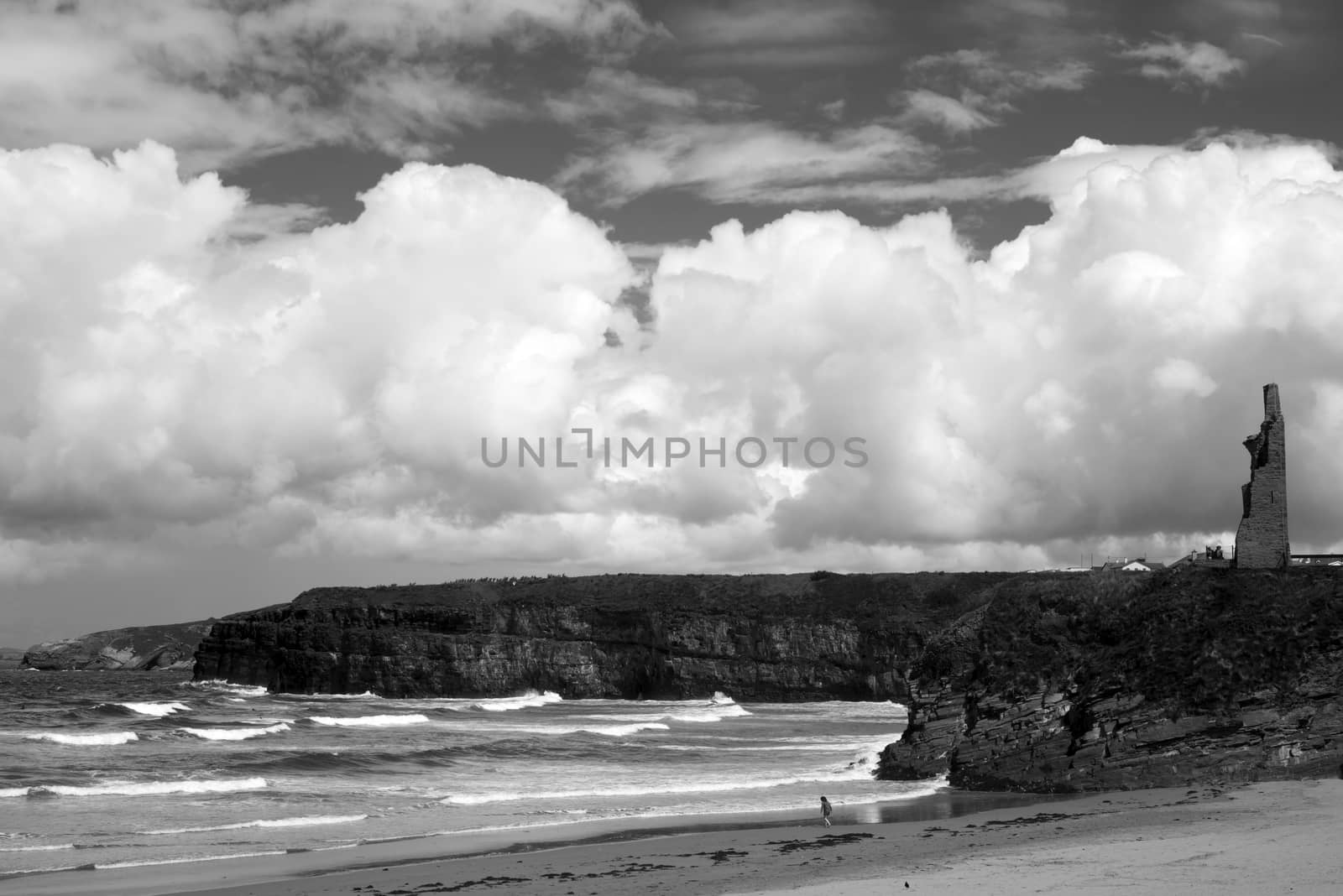 young woman on the beach with cliffs and castle on ballybunion beach county kerry ireland