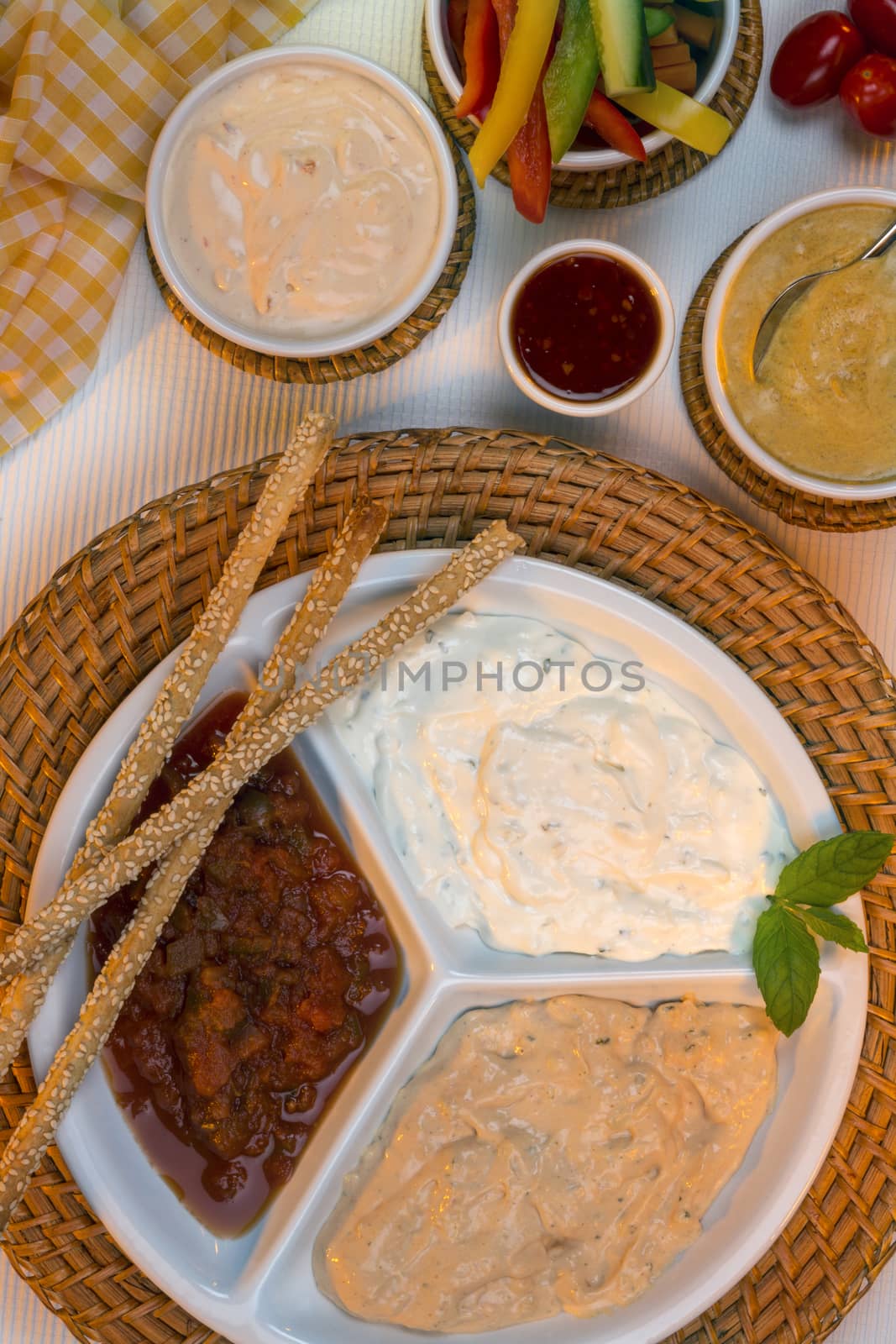 A selection of party dips with bread sticks, pita bread and other crudites.