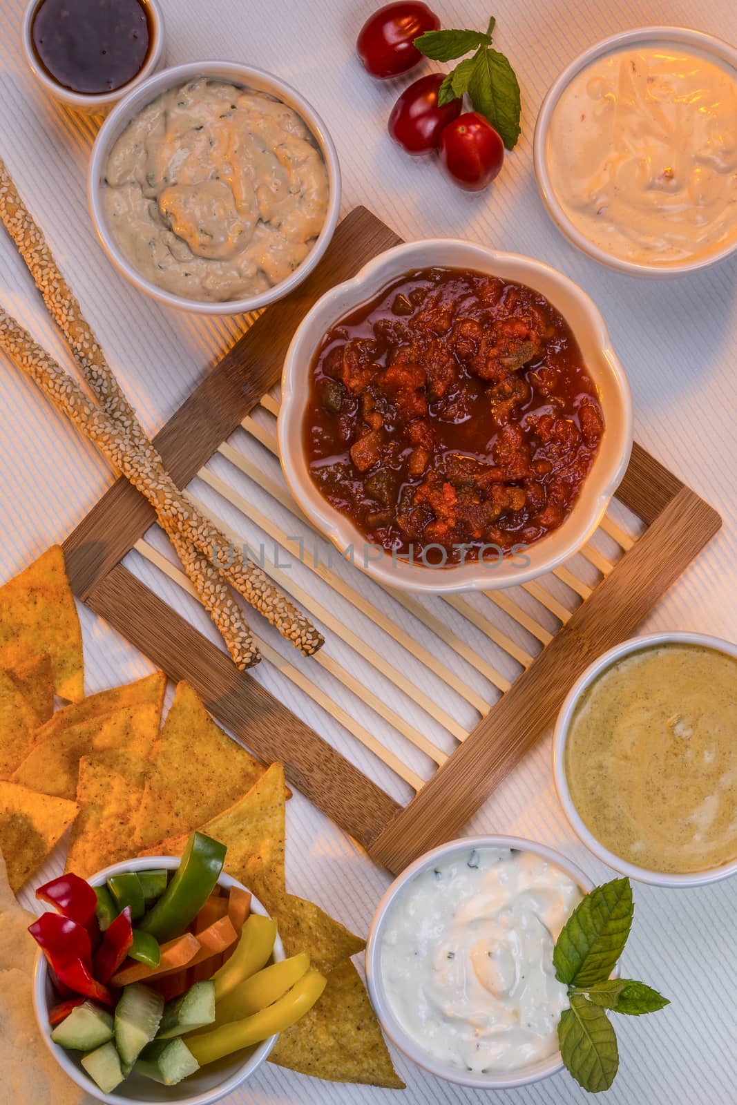 A selection of party dips with bread sticks and other crudites.