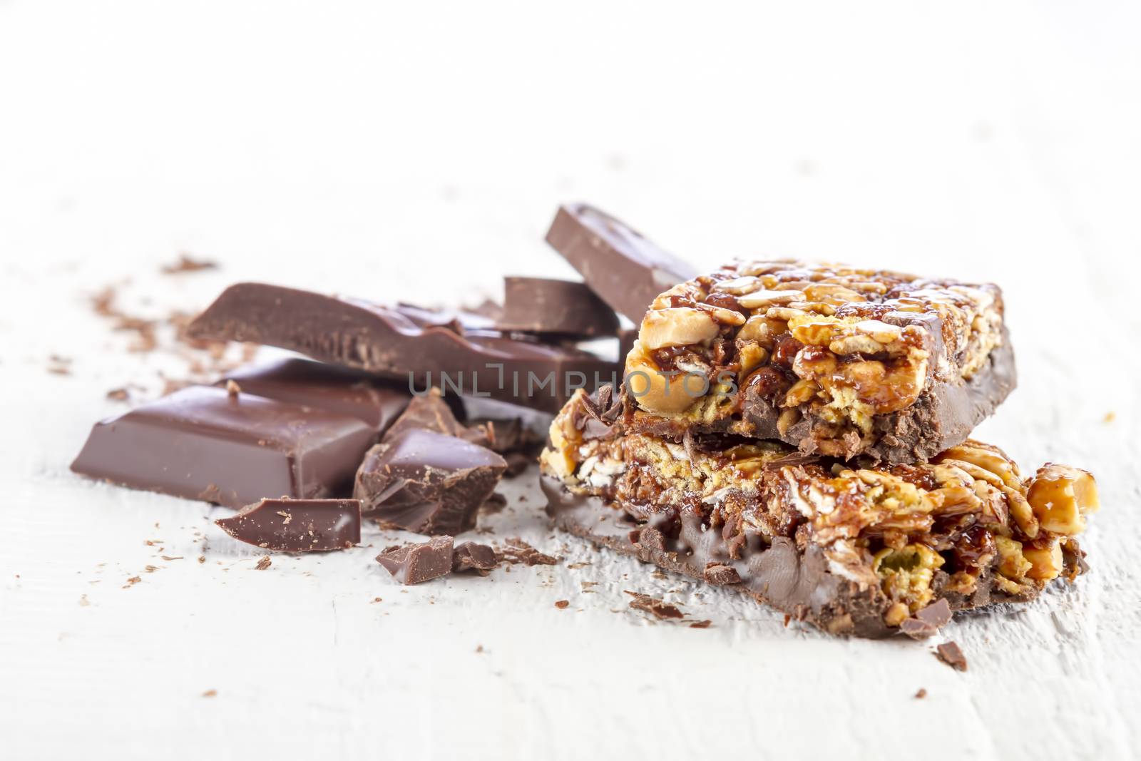 granola bar with chocolate on white wooden background