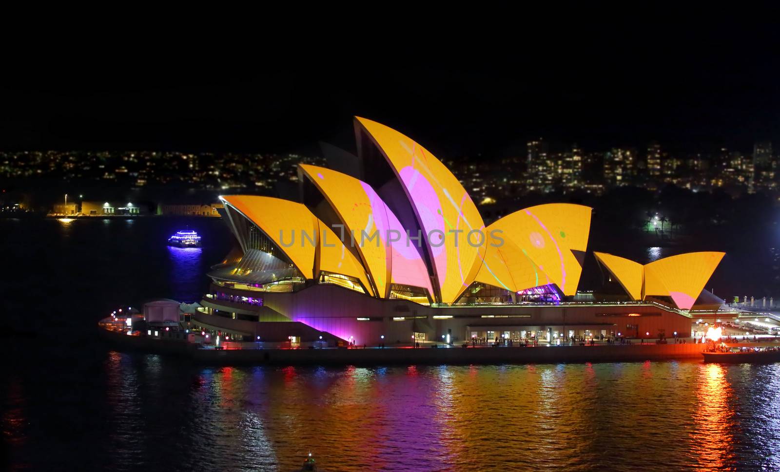 SYDNEY, AUSTRALIA - MAY 27, 2015; The Sydney Opera House comes alive each night during Vivid Sydney... instead of the usual white lights lighting up its unique roof, these beautiful colours and patterns adorn it. Here the roof alight in vivid yellow, orange and pink. 8000 iso