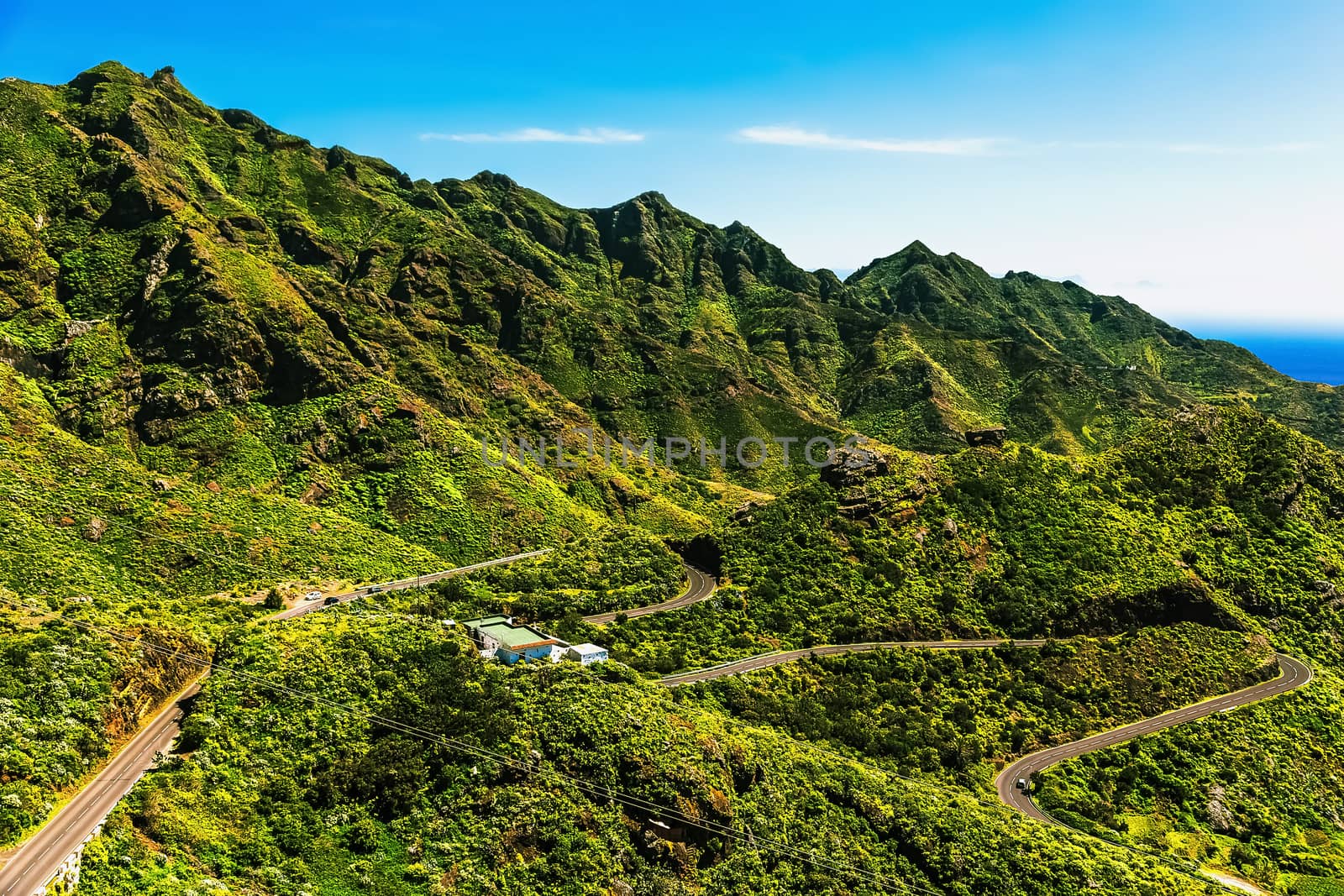 Green mountains or rocks valley with winding or serpantine road and sky nature landscape in Tenerife Canary island, Spain at summer