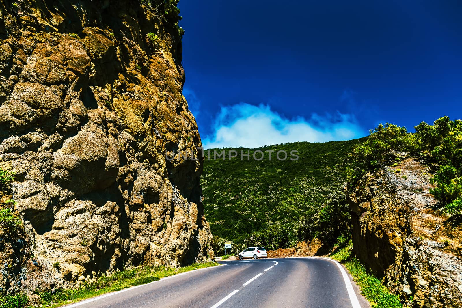 Asphalt road in green mountains with blue sky and clouds in Tenerife Canary island, Spain at spring or summer