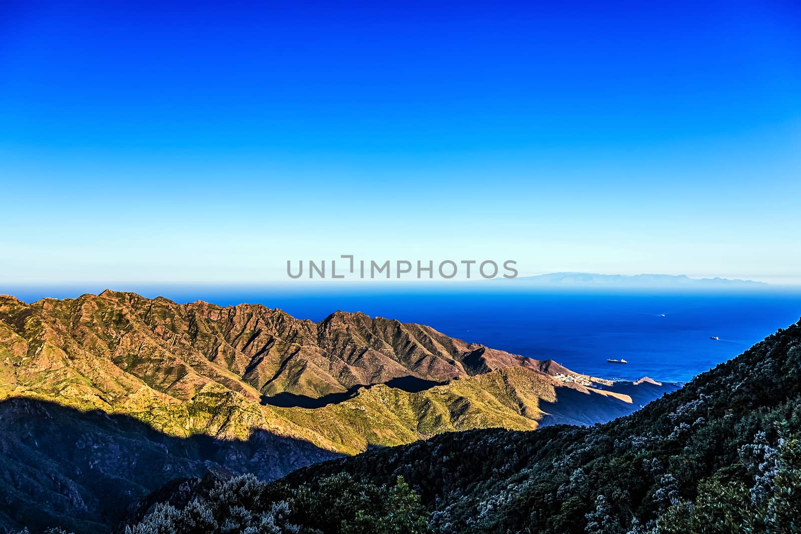 Coast of Atlantic ocean with green mountain or rock and  sky with skyline or horizon in Tenerife Canary island, Spain at spring or summer