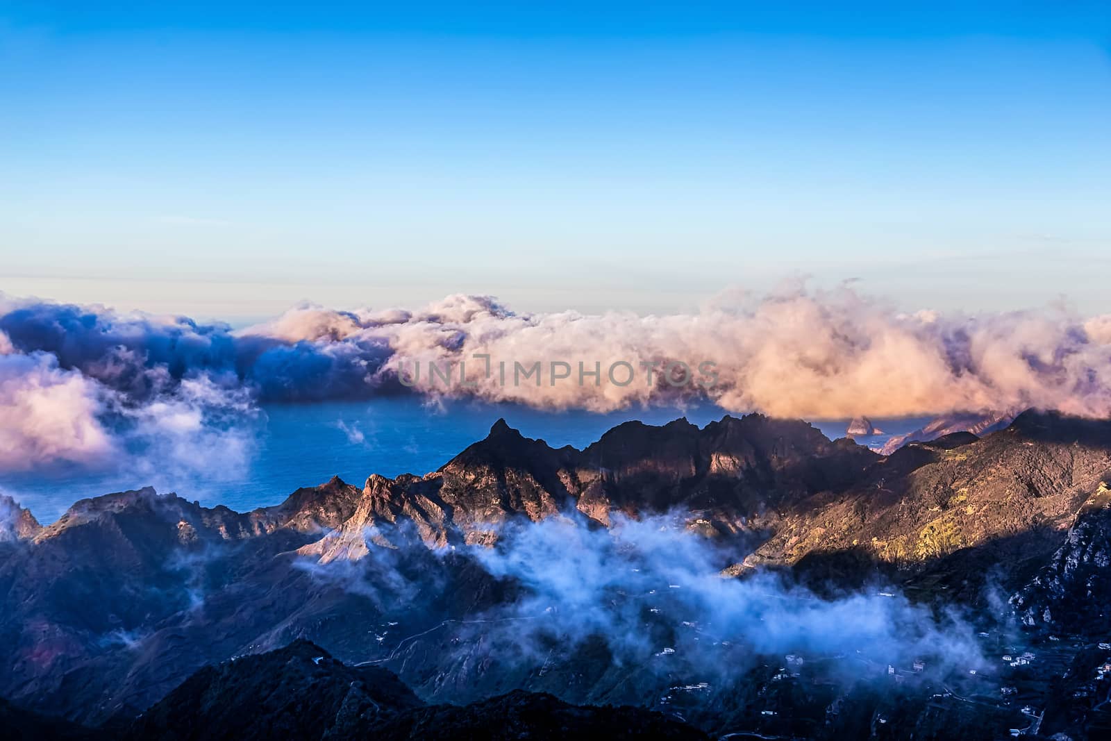 Mountains with white and pink clouds on blue sky landscape in Tenerife island, Spain at sunset